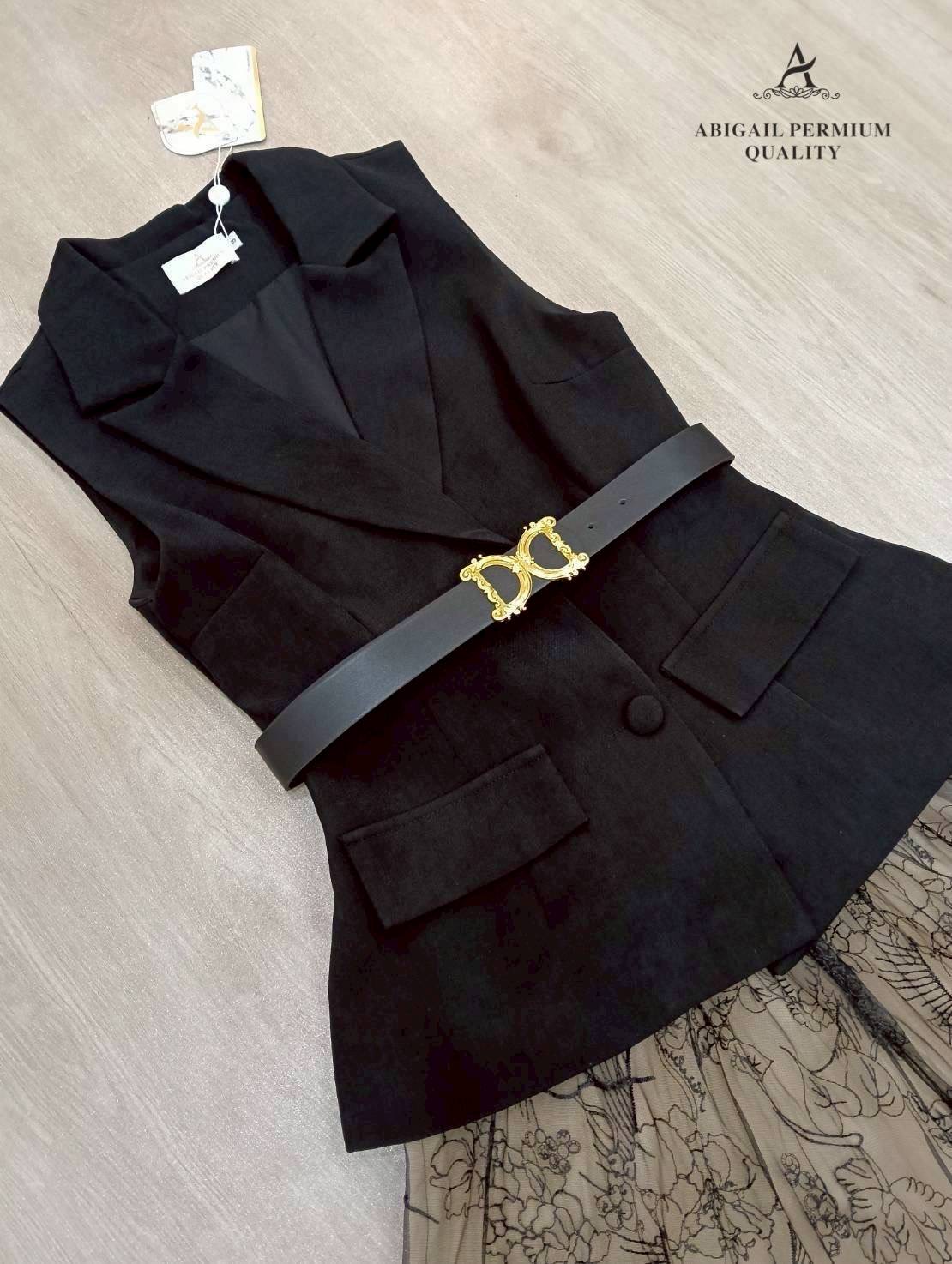 เสื้อแขนกุดเบลเซอร์สีดำ ดีไซน์คอวีลึก เพิ่มความเรียบหรูพร้อมกระดุมด้านหน้าและกระเป๋าดีไซน์เรียบเท่ ดึงความสนใจด้วยเข็มขัดหนังหัวสีทองที่ช่วยเน้นทรวดทรงและเพิ่มความพรีเมียม กระโปรงยาวทรงเอ ผ้าซีทรูสองชั้น ด้านในเป็นผ้าสีเบจเรียบ ส่วนด้านนอกเป็นผ้าทูลล์สีดำ