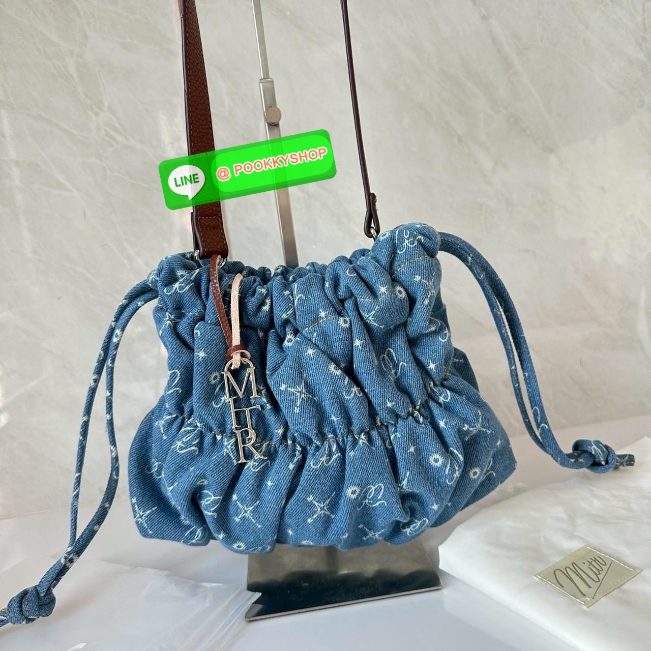 Mitr scrunchy bag 🔖กระเป๋ายีนส์สุดน่ารักเนื้อนุ่มพิมพ์ลาย Monogram ของ Mitr จุของได้เยอะรูปทรงแบบรูดได้ น้ำหนักเบาสุดๆ สะพายเป็น Shoulder Bag หรือถอดสายและถือเป็น Clutch Bag ก็ได้ ดีเทล Charm ห้อยโลหะสีเงิน โดดเด่นสุดๆ