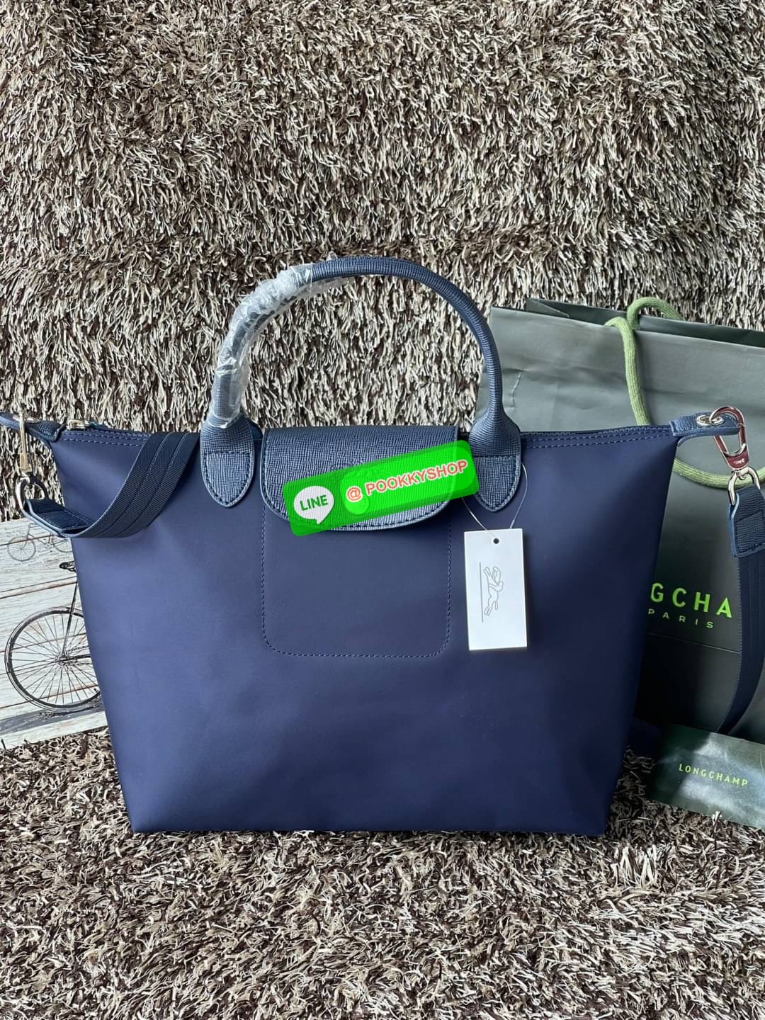 Longchamp Le Pliage Neo Size M มาพบกับกระเป๋ารุ่นยอดนิยม ที่สาวๆ ต้องมีไว้เก็บไว้สักใบ กระเป๋าโท้ทใบนี้ มาพร้อมกับสีที่มีสไตล์เรียบง่าย มีสายสะพายยาวช่วยให้คุณสามารถสะพายไหล่ได้อย่างสบาย ในขณะที่ที่ปิดแบบซิปช่วยให้คุณมั่นใจได้ว่าของด้านในมีความปลอดภัย Le