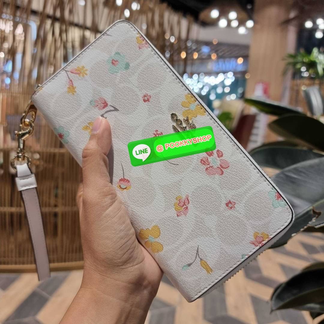 COACH C8695 LONG ZIP AROUND WALLET IN SIGNATURE CANVAS WITH MYSTICAL FLORAL PRINT พร้อมเสิร์ฟความหรู กับคอลใหม่ล่าสุด กระเป๋าสตางค์ใบยาวกึ่งคล้องมือ มาในดีไซน์ผู้ดี เรียบหรู ถือใช้แล้วขับผิวมาก ลวดลายดอกไม้คละเคล้าสวยงาม วัสดุหนังแคนวาสเคลือบลาย มาพร้อมสา