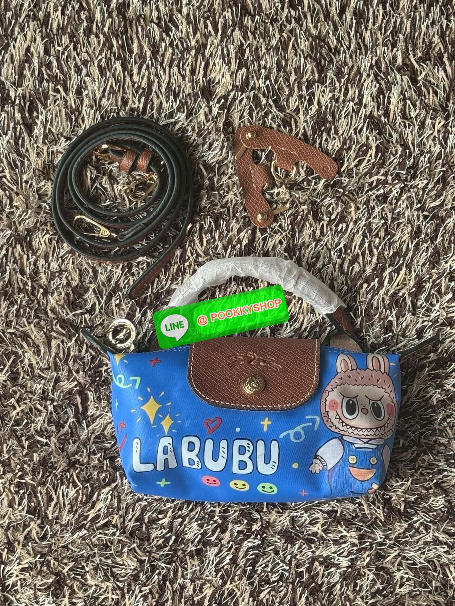 LONGCHAMP LE PLIAGE ORIGINAL X Labubu Pouch with handle เป็นการร่วมงานกัระหว่างแบรนด์ และยังกระเป๋าถือขนาดมินิทรงpouch ที่ด้านหน้ามีลวดลายน้องลาบูบู้ในแบบต่างๆ เปิดปิดระบบสองชั้น ได้ว่าของด้านในมีความปลอดภัย เหมาะอย่างยิ่งสำหรับสาวๆที่ชอบกระเป๋าขนาดมินิไซ