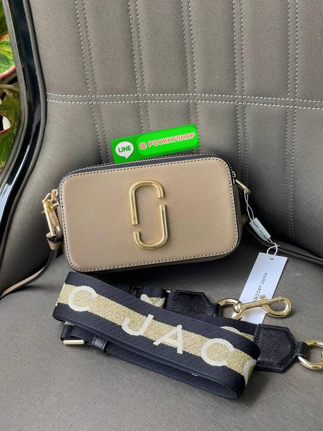 Marc Jacobs Snapshot Bag กระเป๋าแบรนด์ดังจากสัญชาติอเมริกัน นับได้ว่ารุ่นนี้เป็นรุ่นทรงฮิตของ marc jacobs เลยทีเดียว โดยด้านหน้ากระเป๋าจะเป็นโลโก้แบบโลหะที่เป็นสัญลักษณ์ของแบรนด์นี้ มาพร้อมสายสะพายที่จะสะพายยังไงก็ดูโดดเด่น เพราะขนาดใหญ่ที่สกรีนตัวอักษร m