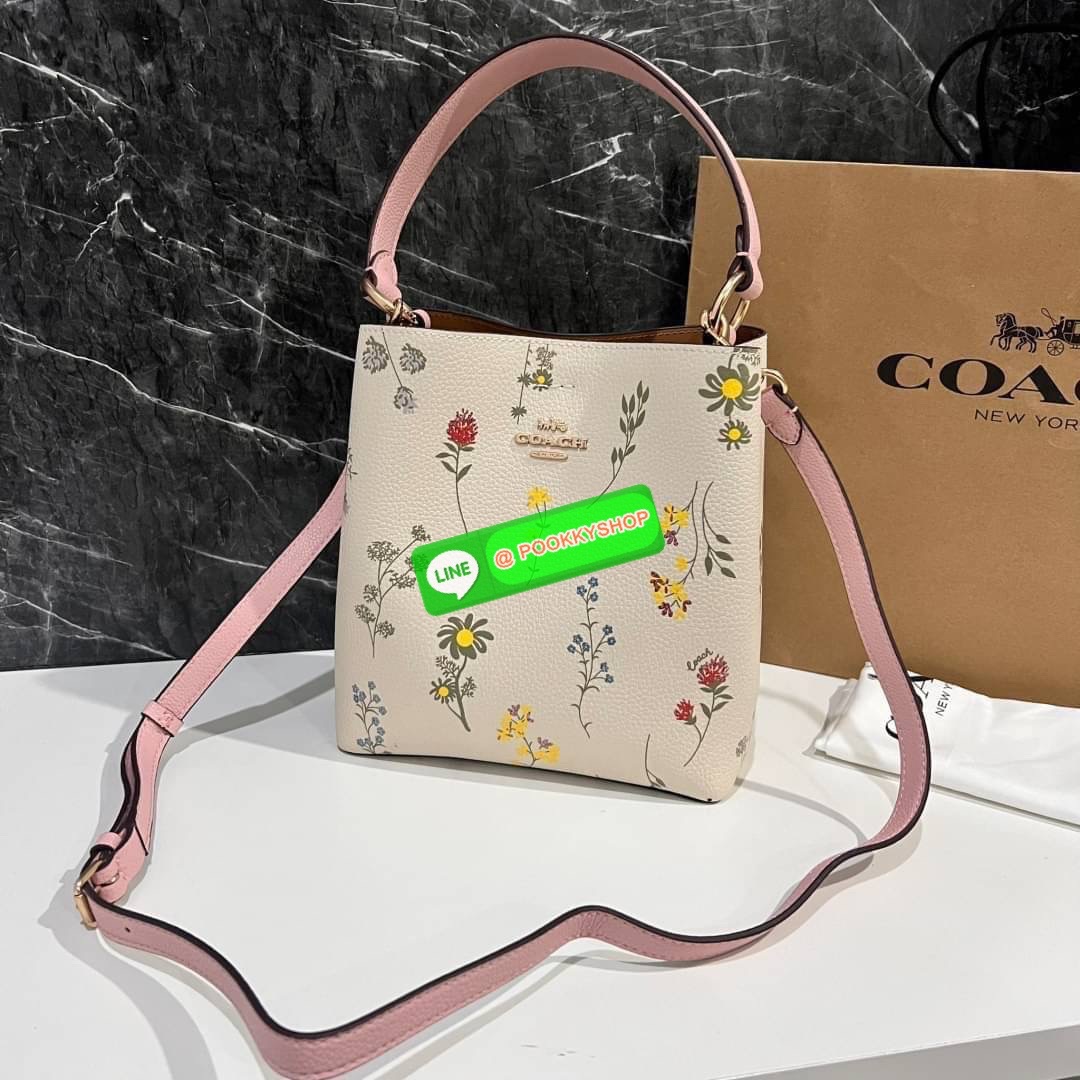 COACH C3598 SMALL TOWN BUCKET WITH SPACED WILDFLOWER PRINT มีความน่ารักละมุนมาก กระเป๋าทรงบัคเก็ต ดีไซน์ดอกไม้คละรอบใบ วัสดุหนังแท้ปากกระเป๋าเปิด-ปิดด้วยกระดุมแม่เหล็ก 2 มีหูจับในตัวและสายสะพายข้าง ภายในโล่งกว้าง มีช่องซิปแยกสัดส่วนตรงกลาง สายสะพายปรับระด