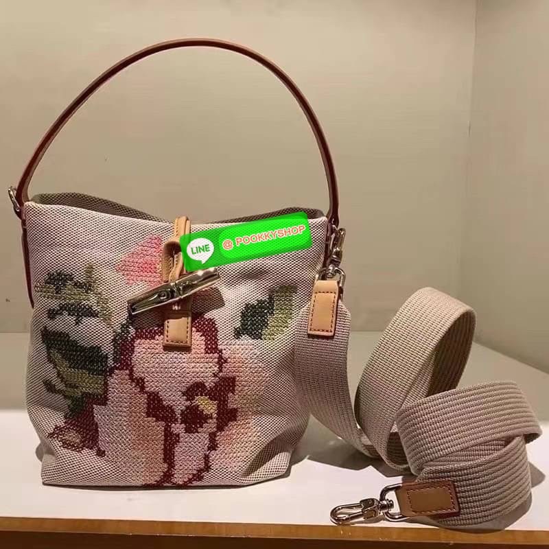 Longchamp Roseau Essential Fleurs กระเป๋าทรงถังขนาดเล็ก วัสดุผ้าฝ้าย ลายปักษ์ดอกกุหลาบ Roseau เป็นคอลเล็คชั่นที่สดใสและเรียบง่าย ซับในสีพื้น อะไหล่สีทอง น้ำหนักเบา จุของได้เยอะ มีสายสะพายไล่ ถอดสายได้ Crossbody ได้