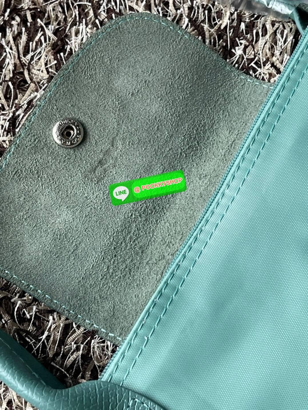 LONGCHAMP LE PLIAGE GREEN Shoulder bag L กระเป๋าโท้ทใบนี้ดึงดูดใจคุณด้วยรูปทรงมินิมอลและปริมาตรที่เพียงพอซึ่งสามารถเก็บเอกสารหรือแล็ปท็อปทั้งหมดของคุณได้อย่างง่ายดาย ด้ามยาวช่วยให้คุณสวมใส่ได้อย่างสบายบนไหล่ ขณะที่การปิดด้วยซิปช่วยให้มั่นใจได้ว่าสิ่งของทั