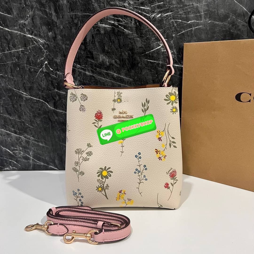 COACH C3598 SMALL TOWN BUCKET WITH SPACED WILDFLOWER PRINT มีความน่ารักละมุนมาก กระเป๋าทรงบัคเก็ต ดีไซน์ดอกไม้คละรอบใบ วัสดุหนังแท้ปากกระเป๋าเปิด-ปิดด้วยกระดุมแม่เหล็ก 2 มีหูจับในตัวและสายสะพายข้าง ภายในโล่งกว้าง มีช่องซิปแยกสัดส่วนตรงกลาง สายสะพายปรับระด