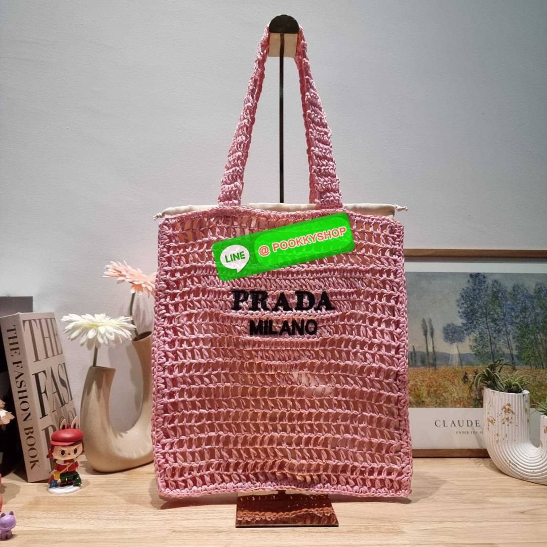 PRADA RAFFIA TOTE BAG สวยไม่ซ้ำใคร สไตล์บีช เหมาะมากกับการสะพายไปเที่ยวทะเล หรือจะใช้ในวันสบายๆก็ตอบโจทย์ กับกระเป๋าสะพายสานใบใหญ่ ตัวกระเป๋าเป็นวัสดุสังเคราห์จากธรรมชาติ สานทอเต็มใบออกมาเป็นลวดลายสวยงาม มีกระเป๋าซับในให้ สำหรับใส่ของเป็นสัดส่วน และรูดปาก