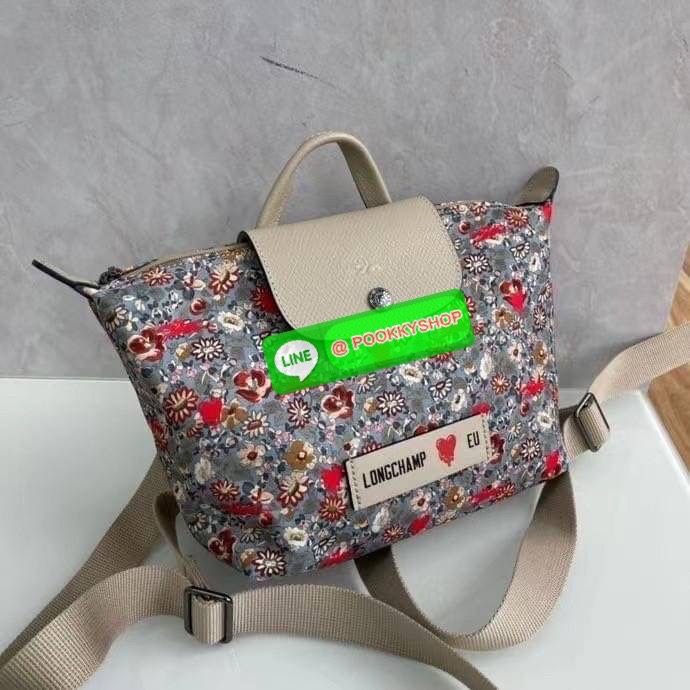 New Arrival Longchamp X Eu Backpack กระเป๋าเป้สะพายหลังลายดอกๆไม้ วัสดุผ้าฝ้าย อะไหล่สีดำ กระเป๋าเป้แบบลำลองสำหรับสตรีซึ่งนำรูปทรงอันเป็นเอกลักษณ์ของ Le Pliage มาปรับใช้กับทุกสถานการณ์ อุปกรณ์เสริมที่ใช้งานได้จริงนี้มีสายรัดปรับระดับได้และที่จับช่วยให้ สะ