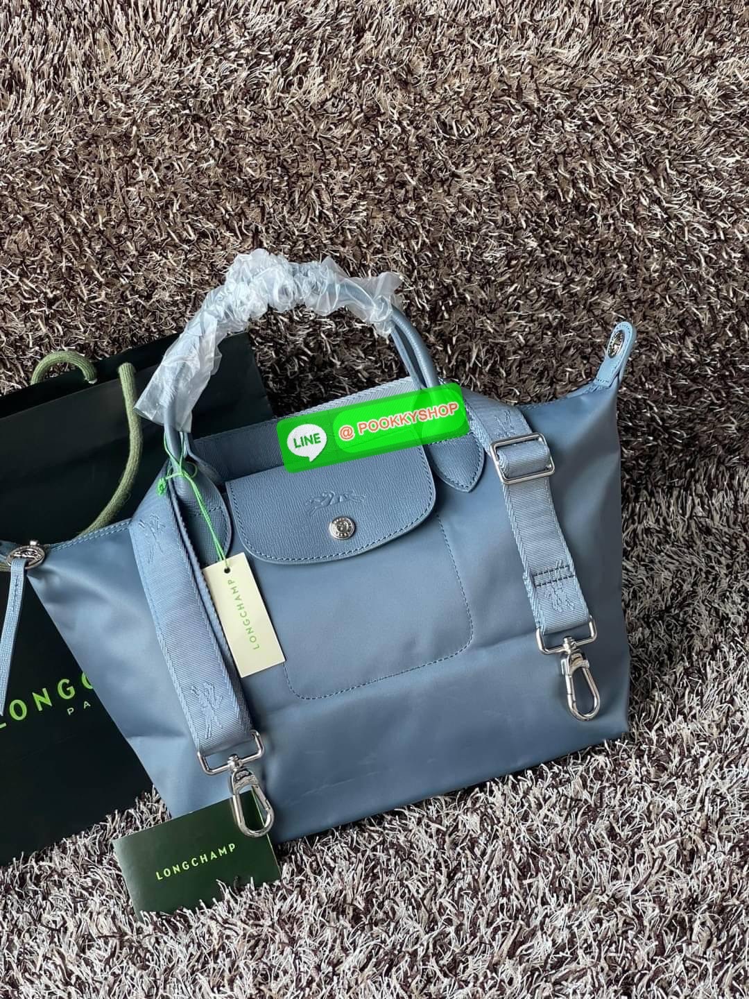 💕Longchamp LE PLIAGE NÉO TOP HANDLE BAG (small size) อีกหนึ่งรุ่นยอดนิยม ที่สาวๆ ต้องมีไว้เก็บไว้สักใบ กระเป๋าโท้ทใบนี้ มาพร้อมกับสีที่มีสไตล์เรียบง่าย มีสายสะพายยาวปรับสั้นยาวได้ช่วยให้คุณสามารถสะพายไหล่ได้อย่างสบาย ในตัวสายปักโลโก้อันเป็นสัญลักษ