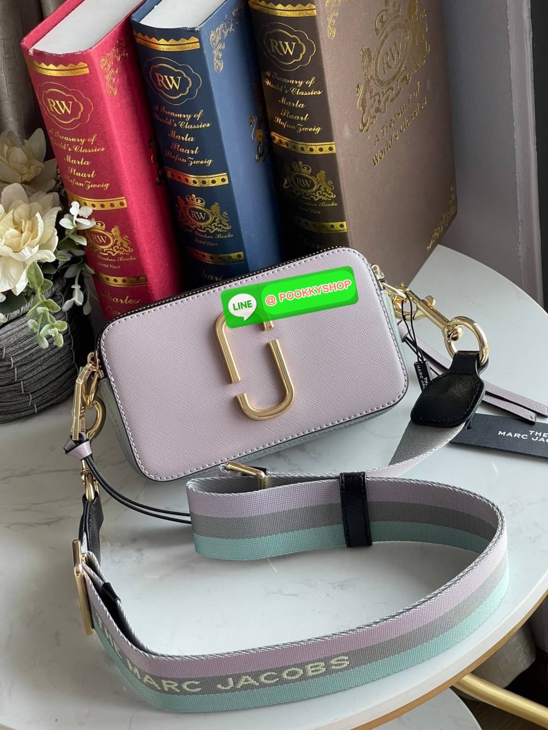 Marc Jacobs Snapshot Bag กระเป๋าแบรนด์ดังจากสัญชาติอเมริกัน นับได้ว่ารุ่นนี้เป็นรุ่นทรงฮิตของ marc jacobs เลยทีเดียว โดยด้านหน้ากระเป๋าจะเป็นโลโก้แบบโลหะที่เป็นสัญลักษณ์ของแบรนด์นี้ มาพร้อมสายสะพายที่จะสะพายยังไงก็ดูโดดเด่น เพราะขนาดใหญ่ที่สกรีนตัวอักษร m