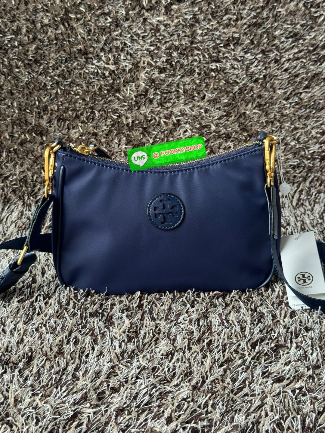 Tory burch nylon web mini hobo เป็นอีกหนึ่งตัวเลือกที่น่าสนใจสำหรับคนที่กำลังมองหากระเป๋าที่เน้นการใช้งาน ดีไซน์เรียบง่าย น้ำหนักเบา เน้นการใช้งานเป็นหลัก อีกทั้งยังมีสายสะพายแบบสปอร์ตช่วยคุณสะพายบนไหล่หรือครอสบอดี้ได้สะดวก ที่สำคัญ ผลิตจากผ้าไนลอนที่มีคว