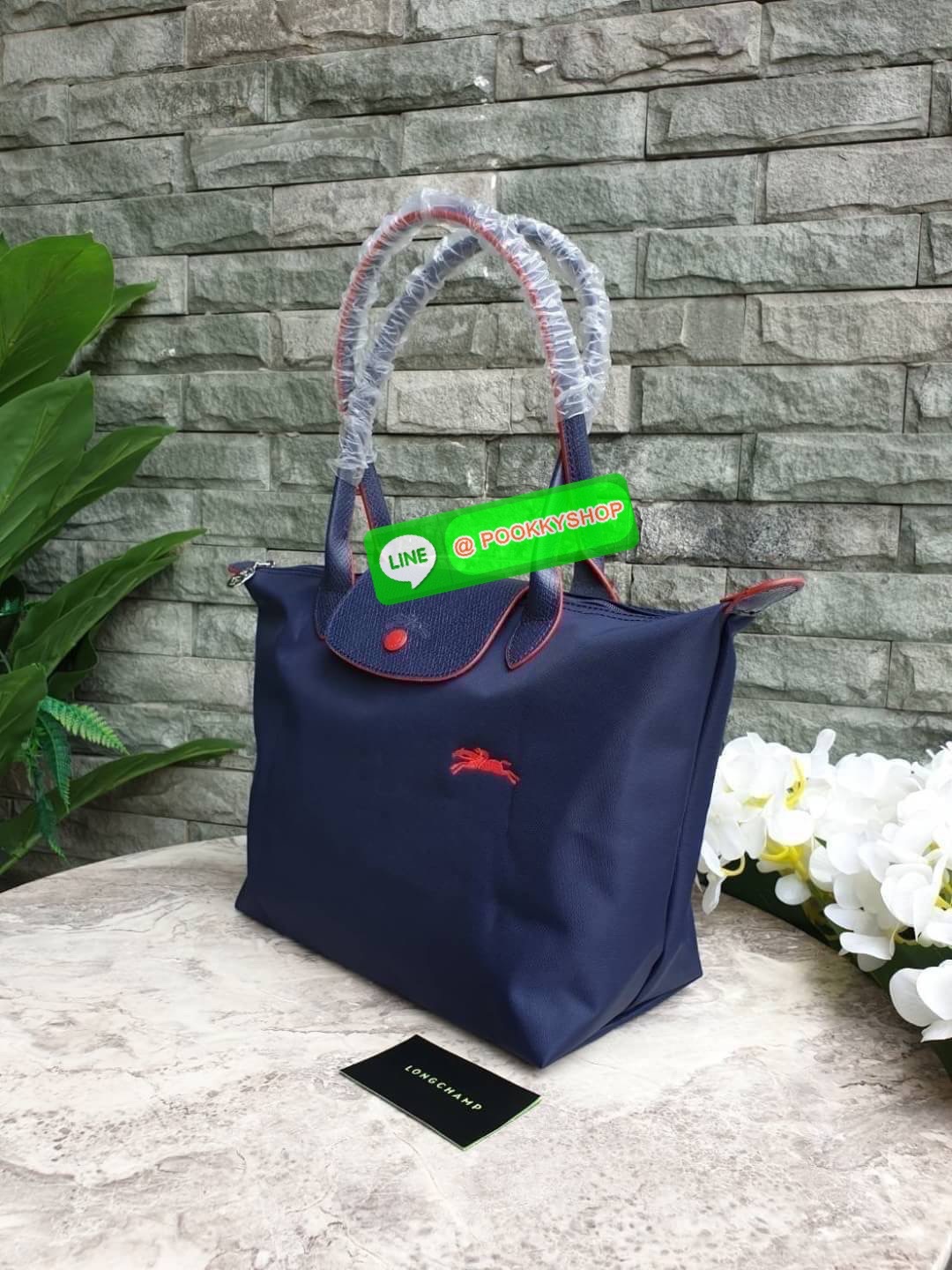 Longchamp Le Pliage Club Tote Bag Size S หูยาว วัสดุเนื้อผ้า Nylon Canvas เคลือบกันนำ้ ตัดด้วยหนังแท้ที่มีน้ำหนักเบา ดีไซน์เรียบง่ายแต่เต็มไปด้วยความคลาสสิก จนเป็นที่ชื่นชอบไปทั่วโลก Longchamp ปรับโฉม LE PLIAGE ด้วยการปักลายรูปม้า-ตราสัญลักษณ์ของแบรนด์บนผ