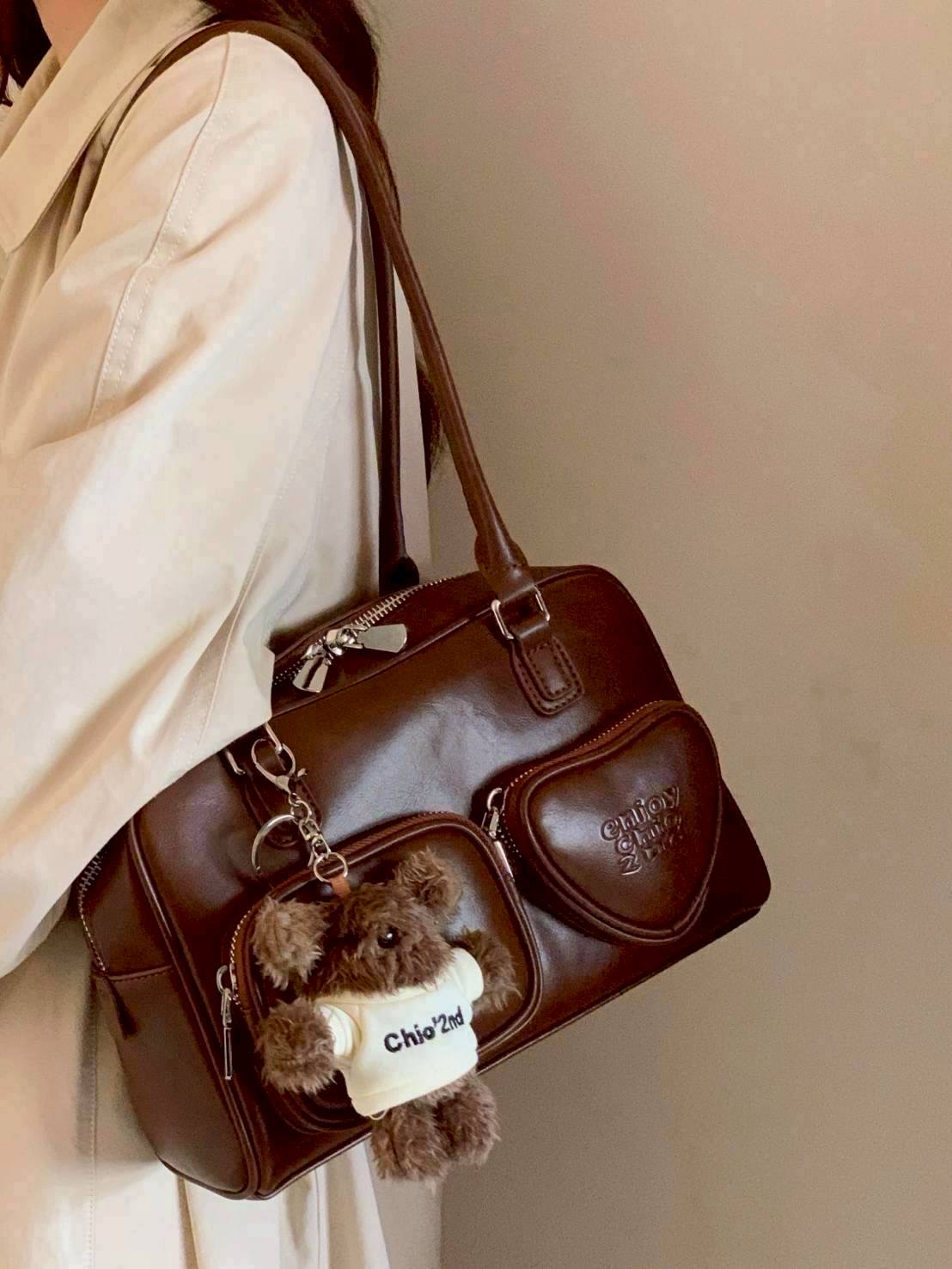 กระเป๋าหนังอย่างดี สีน้ำตาล ปั้มอักษร enjoy มีช่องซิปหน้า 2ช่อง แถมพวงกุญแจตุ๊กตาขนนุ่มน่ารัก หูกระเป๋ายาวคล้องไหล่ คล้องแขนหรือถือได้หมด งานเกรดแพง สวยตรงปก