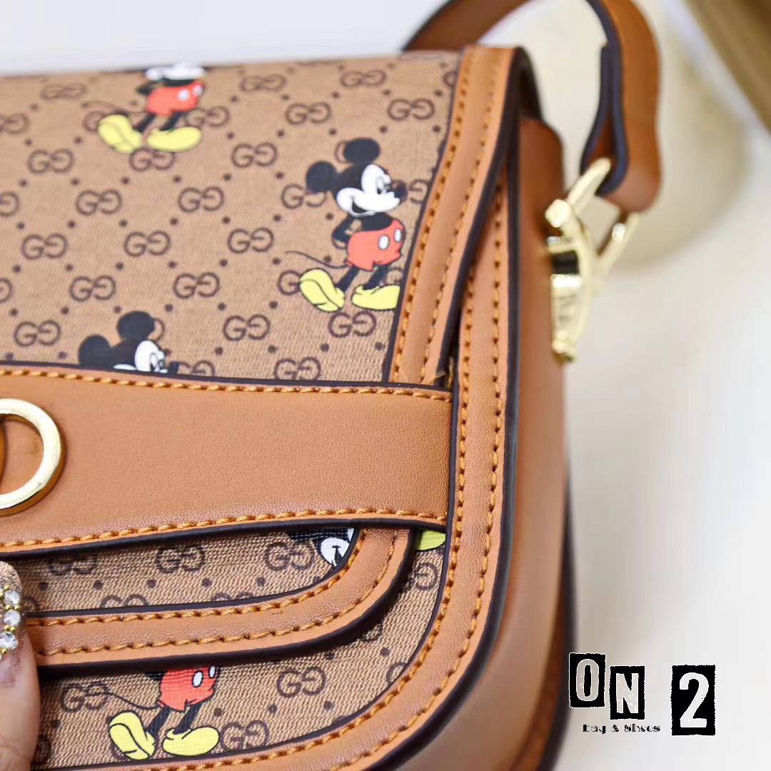 กุชชี่สะพายข้างทรงฝาปิดวัสดุตัวกระเป๋าทำจากหนังแคนวาสลายมิกกี้เม้าส์ อะหลั่ยสีทอง ด้านในซับผ้าทออย่างหนา งานปั๊มทุกจุด สายยาวเป็นหนังอย่างดีสีน้ำตาล
