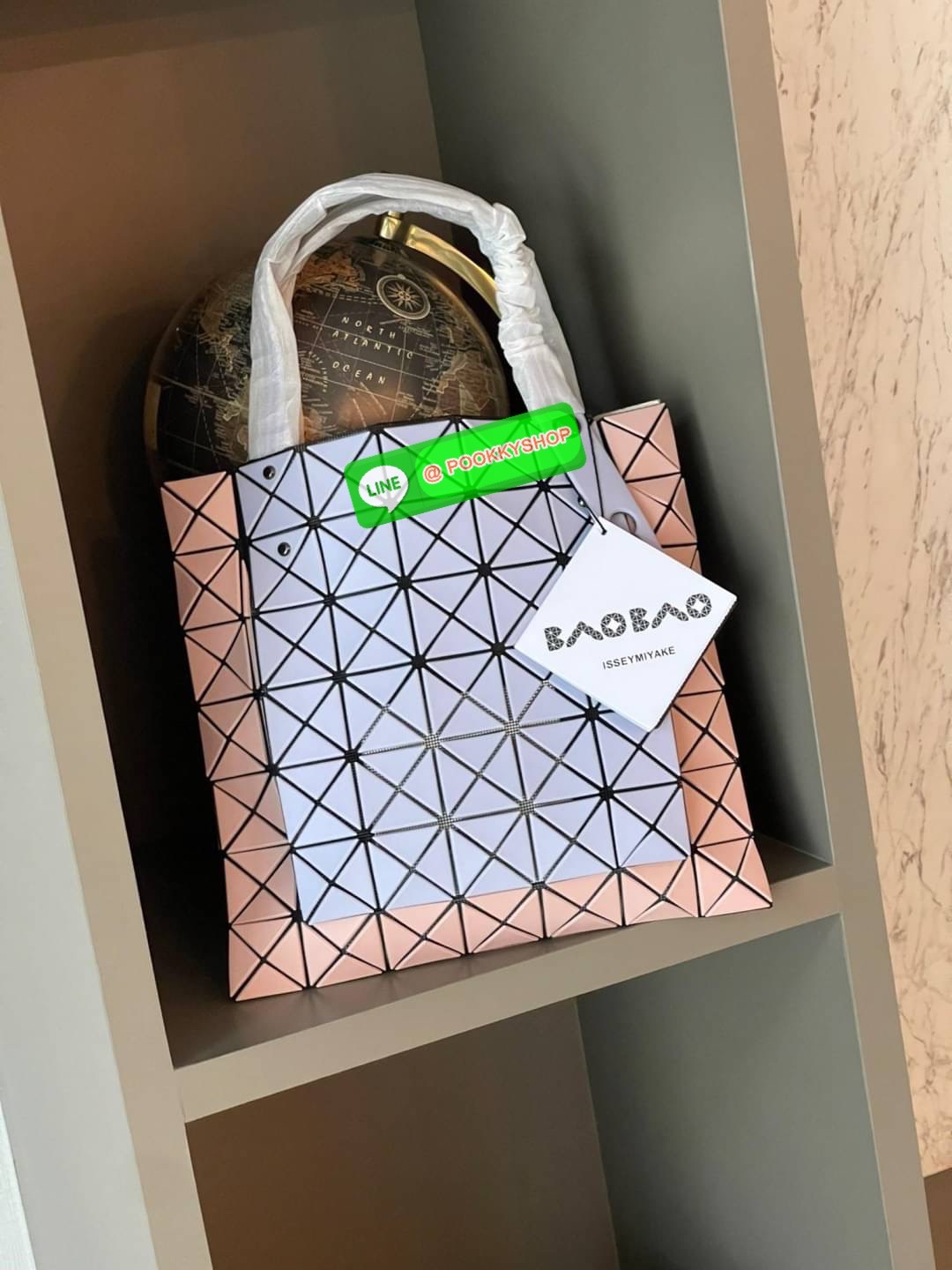 Baobao Issey Miyake Prism Kangaroo tote bag กระเป๋าถือทรงโท้ทที่ประดิษฐ์ขึ้นอย่างเชี่ยวชาญในญี่ปุ่น มาพร้อมแผงเรขาคณิตสำหรับการออกแบบที่ได้รับแรงบันดาลใจจากกระดาษพับ ซิลลูเอทอันเป็นเอกลักษณ์นี้ปิดท้ายด้วยสายรัดแบบอสมมาตร มีการพัฒนาโครงสร้างทรงสามเหลี่ยมเพ