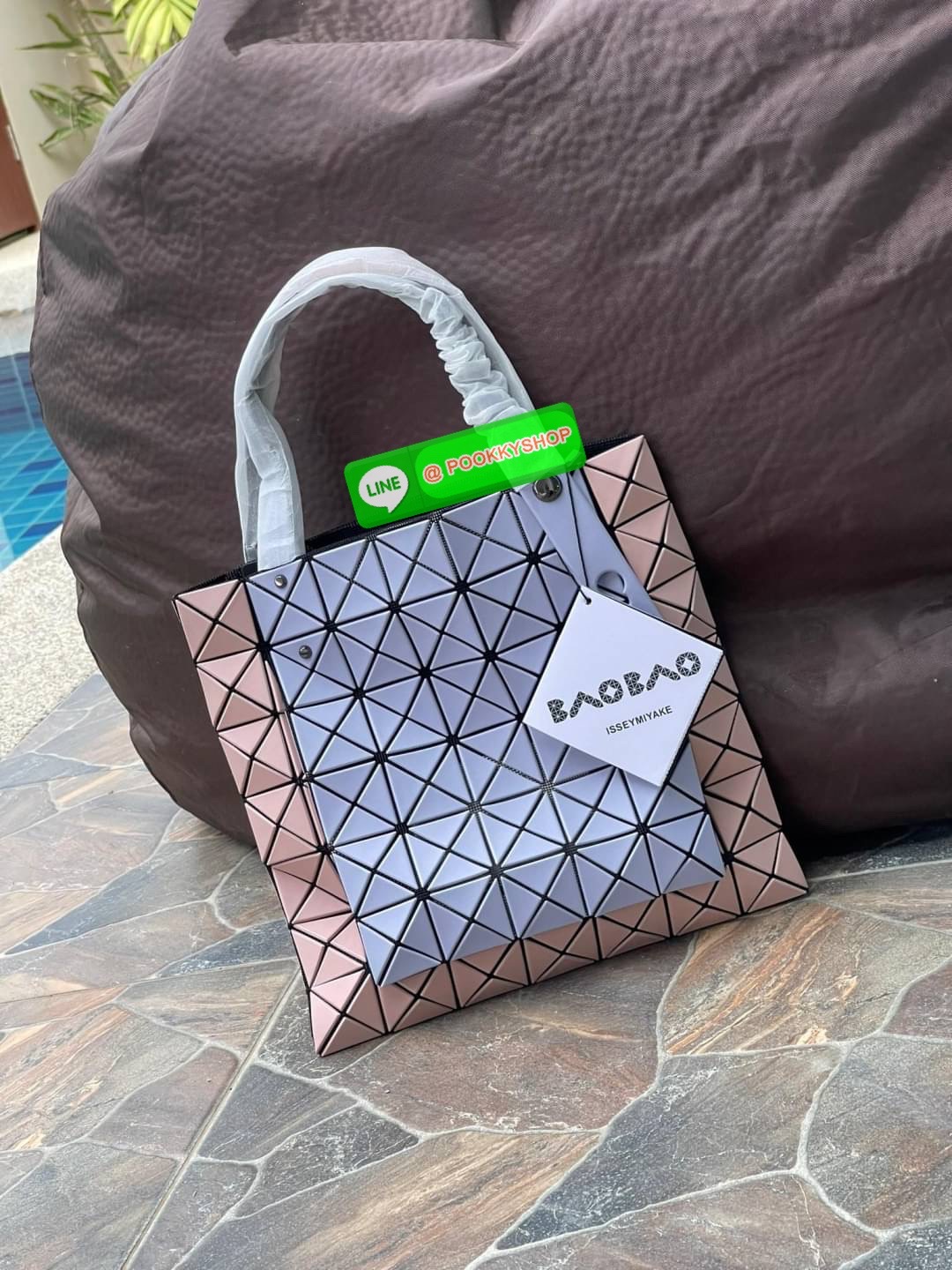 Baobao Issey Miyake Prism Kangaroo tote bag กระเป๋าถือทรงโท้ทที่ประดิษฐ์ขึ้นอย่างเชี่ยวชาญในญี่ปุ่น มาพร้อมแผงเรขาคณิตสำหรับการออกแบบที่ได้รับแรงบันดาลใจจากกระดาษพับ ซิลลูเอทอันเป็นเอกลักษณ์นี้ปิดท้ายด้วยสายรัดแบบอสมมาตร มีการพัฒนาโครงสร้างทรงสามเหลี่ยมเพ