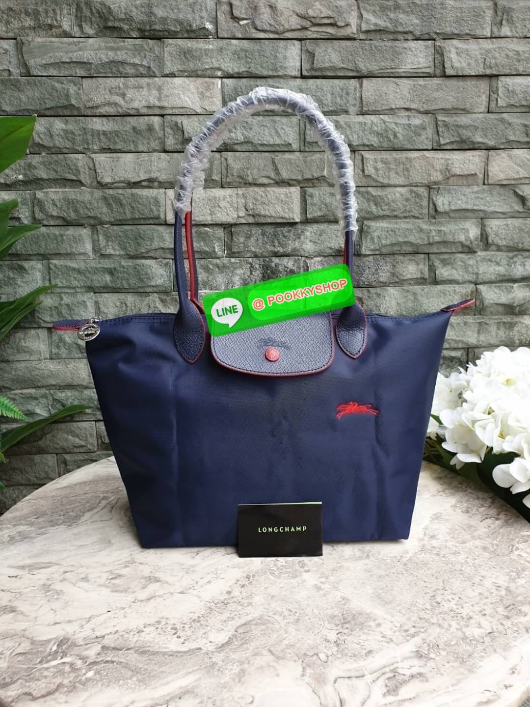 Longchamp Le Pliage Club Tote Bag Size S หูยาว วัสดุเนื้อผ้า Nylon Canvas เคลือบกันนำ้ ตัดด้วยหนังแท้ที่มีน้ำหนักเบา ดีไซน์เรียบง่ายแต่เต็มไปด้วยความคลาสสิก จนเป็นที่ชื่นชอบไปทั่วโลก Longchamp ปรับโฉม LE PLIAGE ด้วยการปักลายรูปม้า-ตราสัญลักษณ์ของแบรนด์บนผ
