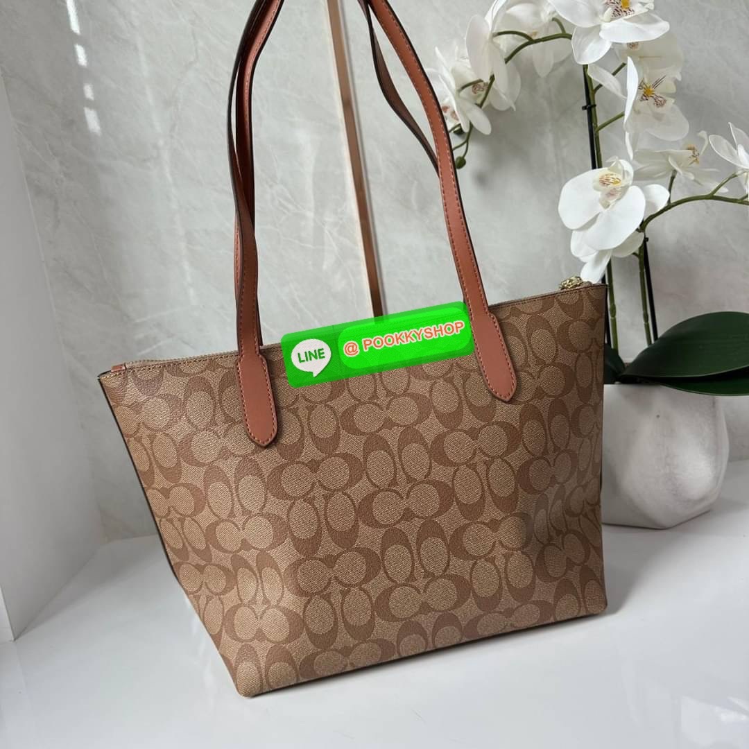 Coach 4455 ZIP TOP TOTE IN SIGNATURE CANVAS กระเป๋าสะพายไหล่ทรง Tote เปิด-ปิดกระเป๋าด้วยซิป ป้องกันของตกหล่น ภายในกว้างใส่สัมภาระได้เยอะ มีช่องเล็กใส่ของจุกจิก วัสดุแคนวาส หูจับหนังแท้ ถือไปเที่ยว ไปทำงาน สะดวกเลยค้า