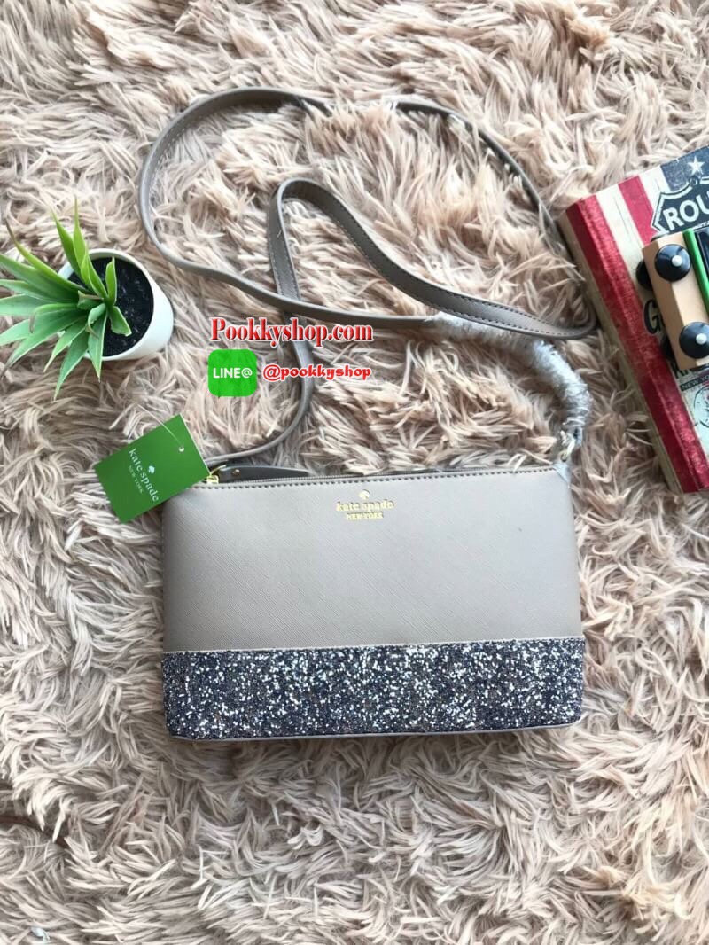 Kate Spade New York Greta Court Ramey Gritter Crossbody Bag กระเป๋าสะพายที่มีดีเทลเป็นกริชเตอร์วิ้งที่ก้นกระเป๋า ด้านบนหนังsaffiano เปิดปิดด้วยซิปเดียวด้านบน ภายในใส่กระเป๋าสตางค์ยาว มินิไอแพคได้ สายสะพายยาว118cmปรับไม่ได้ ขนาดกำลังดีสวยน่าใช้เลยคร้า!!