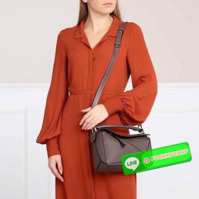 Loewe Puzzle Bag In Classic กระเป๋าทรง Puzzle นี้ออกแบบโดย Jonathan Anderson โดยได้รับแรงบันดาลใจในการออกแบบมาจากรูปทรงของลูกรักบี้ ดังนั้น จึงจะเห็นได้ว่าการตัดเย็บและรูปทรงของกระเป๋านั้นคล้ายคลึงกับลูกรักบี้ รูปทรงดูมินิมอลไม่ทิ้งคอนเซ็ปต์ของแบรนด์ สามา