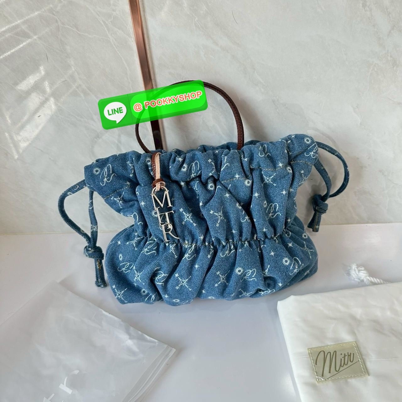 Mitr scrunchy bag 🔖กระเป๋ายีนส์สุดน่ารักเนื้อนุ่มพิมพ์ลาย Monogram ของ Mitr จุของได้เยอะรูปทรงแบบรูดได้ น้ำหนักเบาสุดๆ สะพายเป็น Shoulder Bag หรือถอดสายและถือเป็น Clutch Bag ก็ได้ ดีเทล Charm ห้อยโลหะสีเงิน โดดเด่นสุดๆ