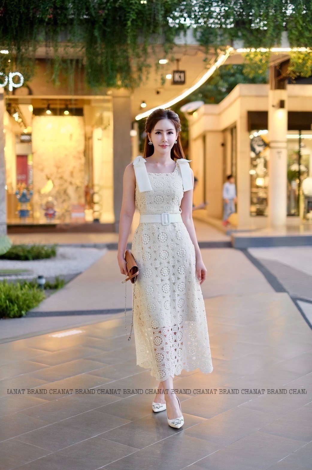 เดรสแฟชั่น เดรสยาวเนื้อผ้าลูกไม้ฉลุวงกลม ดีไซน์แขนกุดตรงบ่าแต่งโบว์ใหญ่สีครีมทั้งสองข้าง