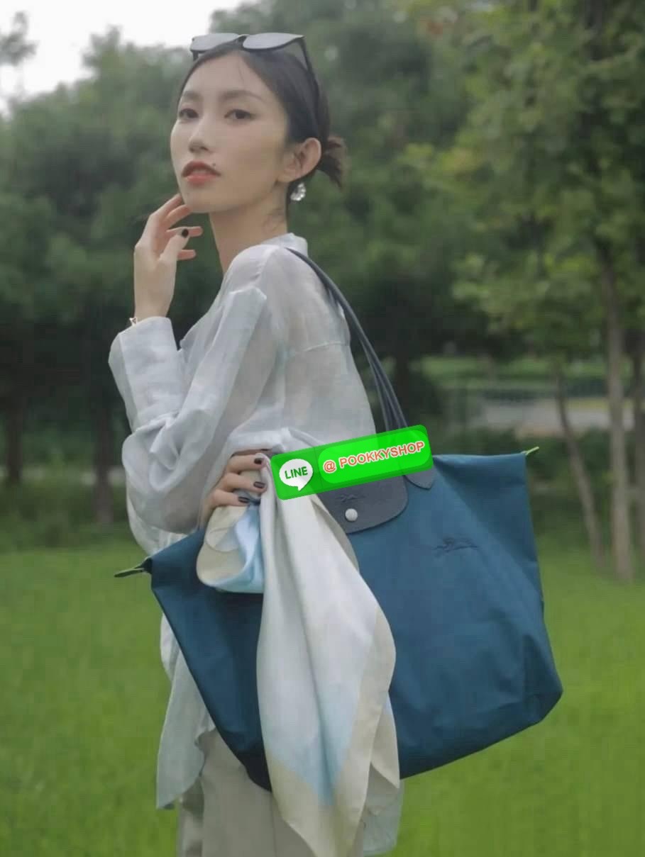 LONGCHAMP LE PLIAGE GREEN Shoulder bag L กระเป๋าโท้ทใบนี้ดึงดูดใจคุณด้วยรูปทรงมินิมอลและปริมาตรที่เพียงพอซึ่งสามารถเก็บเอกสารหรือแล็ปท็อปทั้งหมดของคุณได้อย่างง่ายดาย ด้ามยาวช่วยให้คุณสวมใส่ได้อย่างสบายบนไหล่ ขณะที่การปิดด้วยซิปช่วยให้มั่นใจได้ว่าสิ่งของทั