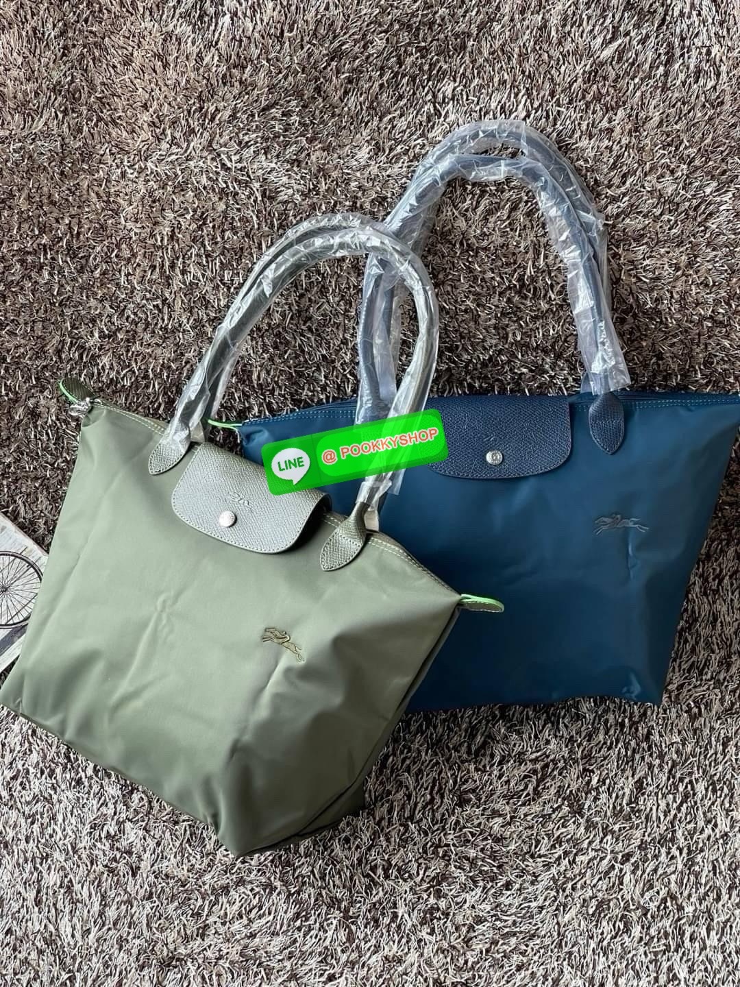 LONGCHAMP LE PLIAGE GREEN Shoulder bag L กระเป๋าโท้ทใบนี้ดึงดูดใจคุณด้วยรูปทรงมินิมอลและปริมาตรที่เพียงพอซึ่งสามารถเก็บเอกสารหรือแล็ปท็อปทั้งหมดของคุณได้อย่างง่ายดาย ด้ามยาวช่วยให้คุณสวมใส่ได้อย่างสบายบนไหล่ ขณะที่การปิดด้วยซิปช่วยให้มั่นใจได้ว่าสิ่งของทั