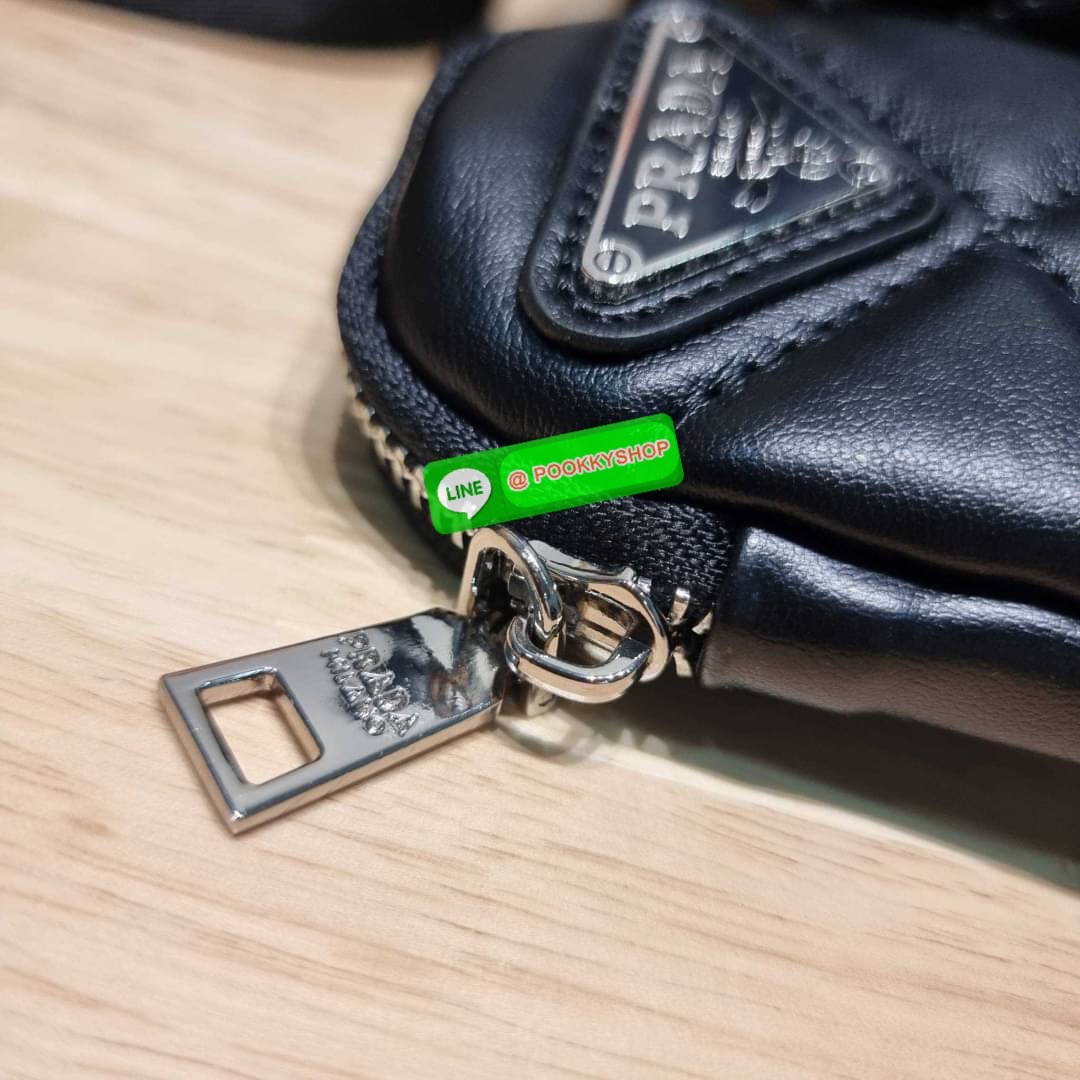 PRADA LEATHER PADDED BAG ใหม่ล่าสุด กับคอลเลคชั่นที่ทำออกมาตอบโจทย์ได้ทุกไลฟ์สไตล์ และเป็นยูนิเซ็กส์ กับกระเป๋าทรงโท้ท ขนาดกำลังดี วัสดุหนังแท้ ตัดเย็บเดินเส้นลายตาราง ปากกระเป๋ามีซิปเปิดปิด ภายในเป็นช่องโล่ง มีช่องแยกให้ มาพร้อมสะพายข้างและใบลูก ให้ได้สน