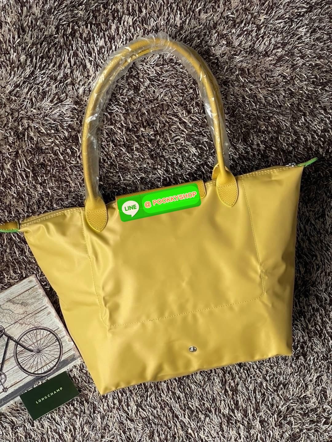 LONGCHAMP LE PLIAGE GREEN Shoulder bag L กระเป๋าโท้ทใบนี้ดึงดูดใจคุณด้วยรูปทรงมินิมอลและปริมาตรที่เพียงพอซึ่งสามารถเก็บเอกสารหรือแล็ปท็อปทั้งหมดของคุณได้อย่างง่ายดาย ด้ามยาวช่วยให้คุณสวมใส่ได้อย่างสบายบนไหล่ ขณะที่การปิดด้วยซิปช่วยให้มั่นใจได้ว่าสิ่งของทั
