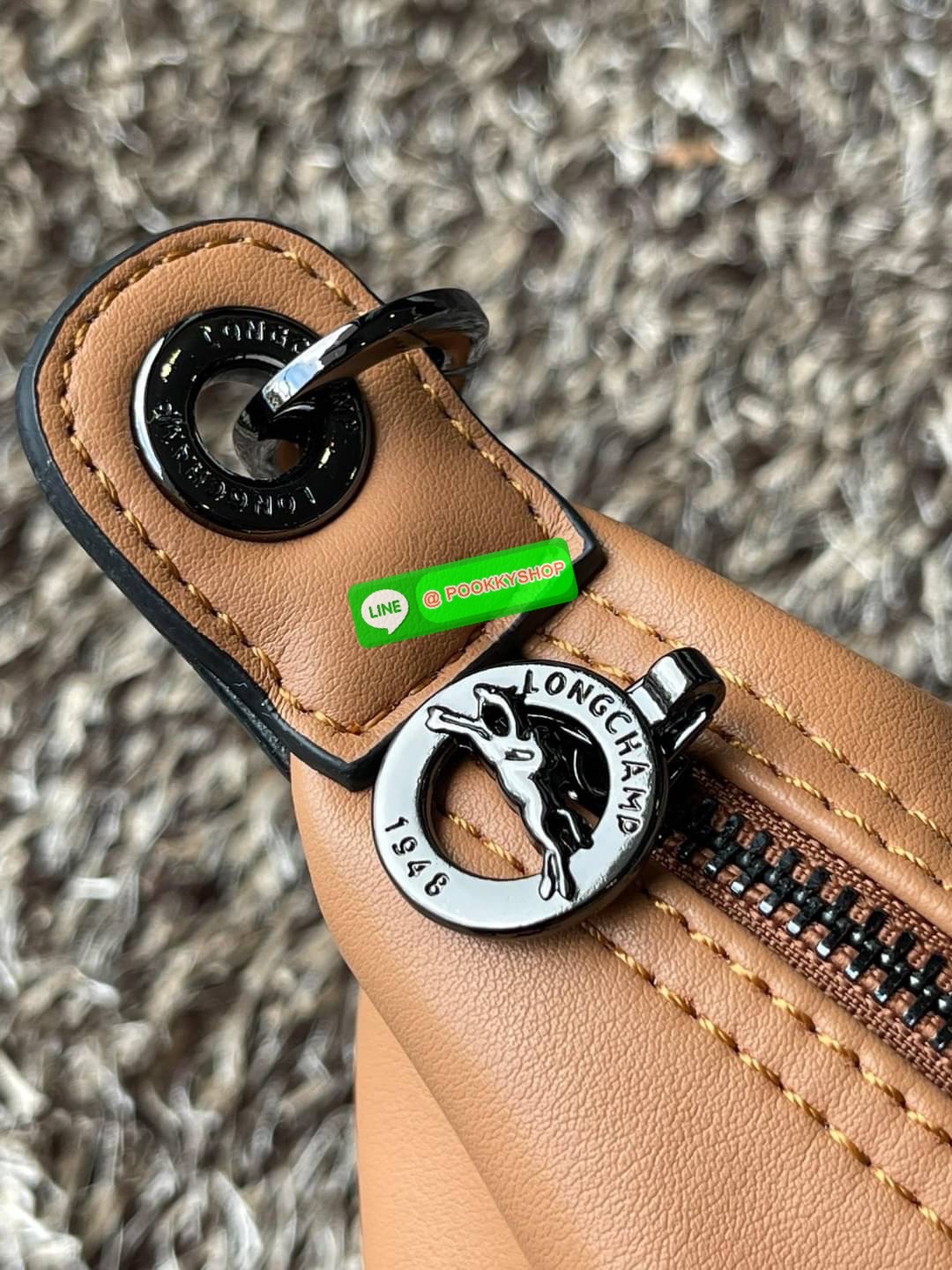 Longchamp LE PLIAGE CUIR TOP HANDLE BAG S เรียกว่าเป็นกระเป๋าอีกหนึ่งรุ่นที่ไม่ว่ายังไงก็ฮอตฮิตและติดเทรนด์ตลอดไม่เคยเปลี่ยนกับ ทรง Le Pliage Cuir หนึ่งในตระกูลกระเป๋าสุดไอคอนิกจากแบรนด์ เมื่อรุ่น Le Pliage Cuir ในรูปแบบของหนังแกะ Metis ได้ถือกำเนิดขึ้นใน