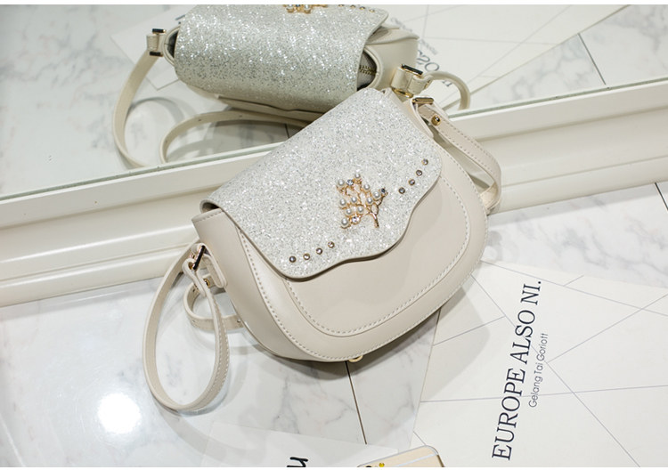 AXIXI กระเป๋าแฟชั่นสตรี รุ่น Tree Pearl สีขาว Off White กระเป๋าสะพายแฟชั่นทรง Saddle สุดน่ารัก เพิ่มความโดดเด่นให้กระเป๋าด้วย Daimond Dust สุดหรูหรา เพิ่มดีเทลให้กับกระเป๋าด้วยอุปกรณ์แต่งกระเป๋าลายต้นไม้สีทองประดับด้วยมุขดูสวยงาม ตัวกระเป๋าผลิตจากหนัง PU
