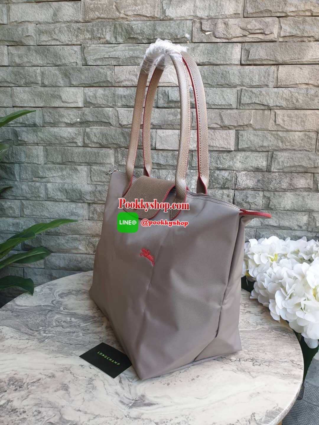 Longchamp Le Pliage Club Tote Bag Size L หูยาว วัสดุเนื้อผ้า Nylon Canvas เคลือบกันนำ้ ตัดด้วยหนังแท้ที่มีน้ำหนักเบา ดีไซน์เรียบง่ายแต่เต็มไปด้วยความคลาสสิก จนเป็นที่ชื่นชอบไปทั่วโลก Longchamp ปรับโฉม LE PLIAGE ด้วยการปักลายรูปม้า-ตราสัญลักษณ์ของแบรนด์บนผ