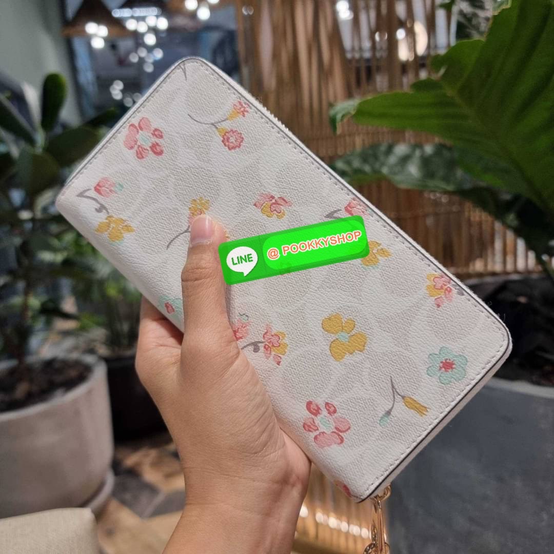 COACH C8695 LONG ZIP AROUND WALLET IN SIGNATURE CANVAS WITH MYSTICAL FLORAL PRINT พร้อมเสิร์ฟความหรู กับคอลใหม่ล่าสุด กระเป๋าสตางค์ใบยาวกึ่งคล้องมือ มาในดีไซน์ผู้ดี เรียบหรู ถือใช้แล้วขับผิวมาก ลวดลายดอกไม้คละเคล้าสวยงาม วัสดุหนังแคนวาสเคลือบลาย มาพร้อมสา