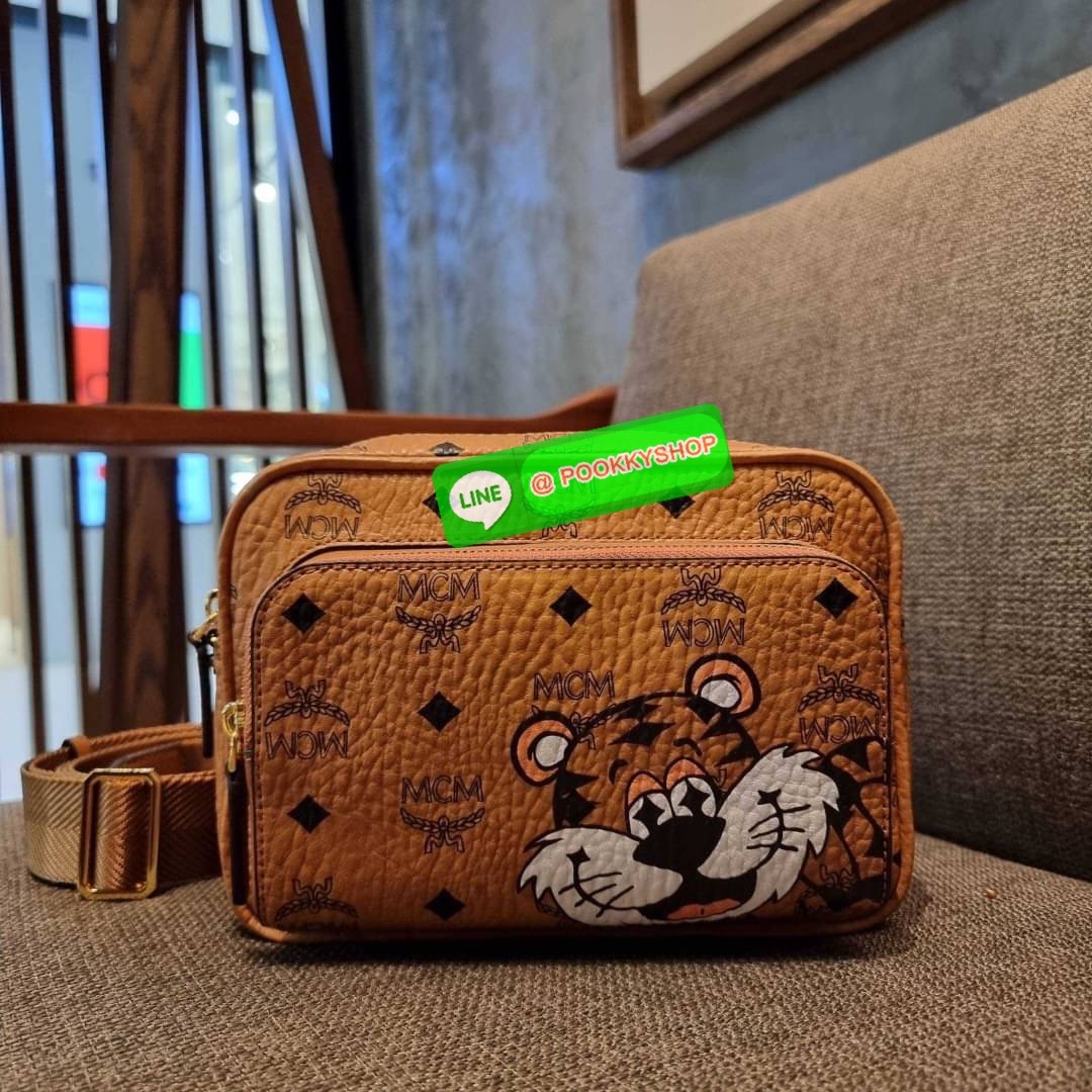 MCM KLASSIK CROSSBODY IN NEW YEAR TIGER VISETOS ใหม่ล่าสุด คอลเลคชั่นรับปีเสือ ของมันต้องมี กระเป๋าสะพายข้างทรงครอสบอดี้ โดดเด่นด้วยลายพริ้นท์น้องเสือคมสวย รุ่นนี้หนุ่มๆหรือสาวๆก็สะพายได้น้า ขนาดกำลังดี วัสดุหนังแคนวาสคุณภาพดี มีช่องหลัก 2 ช่อง เปิด-ปิดด้