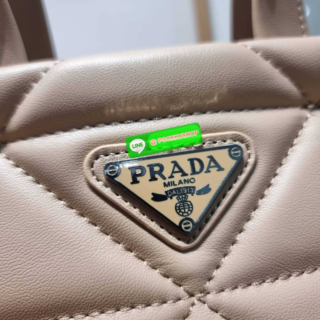 PRADA LEATHER PADDED BAG ใหม่ล่าสุด กับคอลเลคชั่นที่ทำออกมาตอบโจทย์ได้ทุกไลฟ์สไตล์ และเป็นยูนิเซ็กส์ กับกระเป๋าทรงโท้ท ขนาดกำลังดี วัสดุหนังแท้ ตัดเย็บเดินเส้นลายตาราง ปากกระเป๋ามีซิปเปิดปิด ภายในเป็นช่องโล่ง มีช่องแยกให้ มาพร้อมสะพายข้างและใบลูก ให้ได้สน