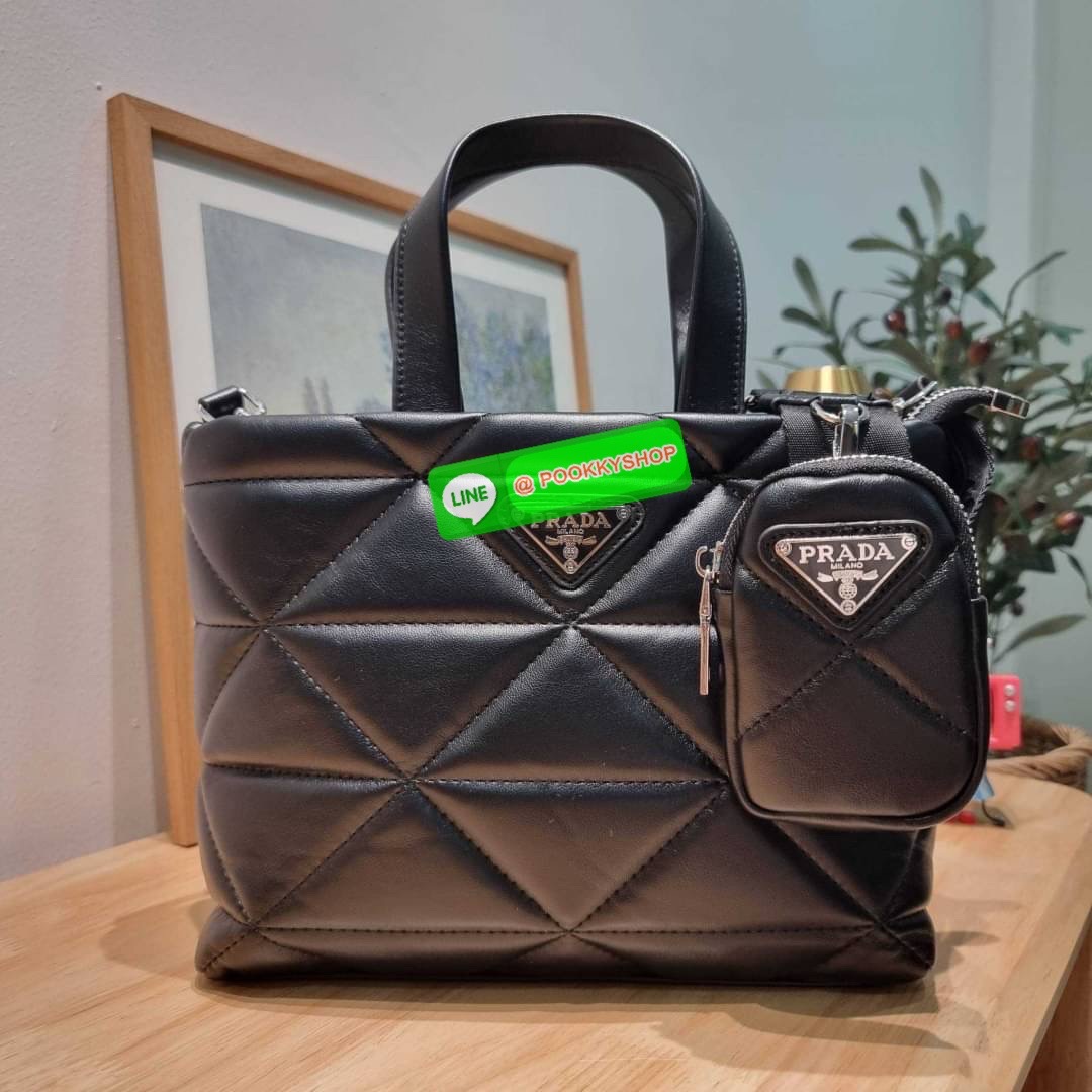 PRADA LEATHER PADDED BAG ใหม่ล่าสุด กับคอลเลคชั่นที่ทำออกมาตอบโจทย์ได้ทุกไลฟ์สไตล์ และเป็นยูนิเซ็กส์ กับกระเป๋าทรงโท้ท ขนาดกำลังดี วัสดุหนังแท้ ตัดเย็บเดินเส้นลายตาราง ปากกระเป๋ามีซิปเปิดปิด ภายในเป็นช่องโล่ง มีช่องแยกให้ มาพร้อมสะพายข้างและใบลูก ให้ได้สน