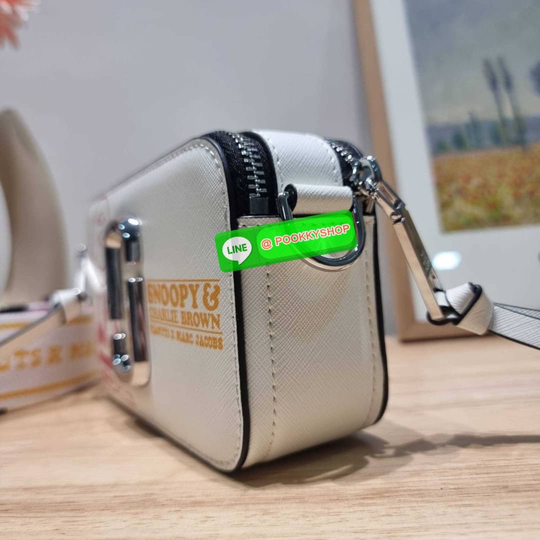 PEANUTS × MARC JACOBS THE SNAPSHOT CROSSBODY BAG คอลเลคชั่นแสนคิวท์ ที่ยกขบวนเหล่าซุปตาร์การ์ตูนมาให้แบบจัดเต็ม กับไอเท็มยอดฮิตที่โดดเด่นเป็นเอกลักษณ์ กระเป๋าสะพายข้างสุดปัง ดีไซน์ลายพรินท์แก๊งค์การ์ตูนสุดฮอต เรียกได้ว่าไม่ซ้ำใคร!! วัสดุหนังวัว สวยอยู่ทรง