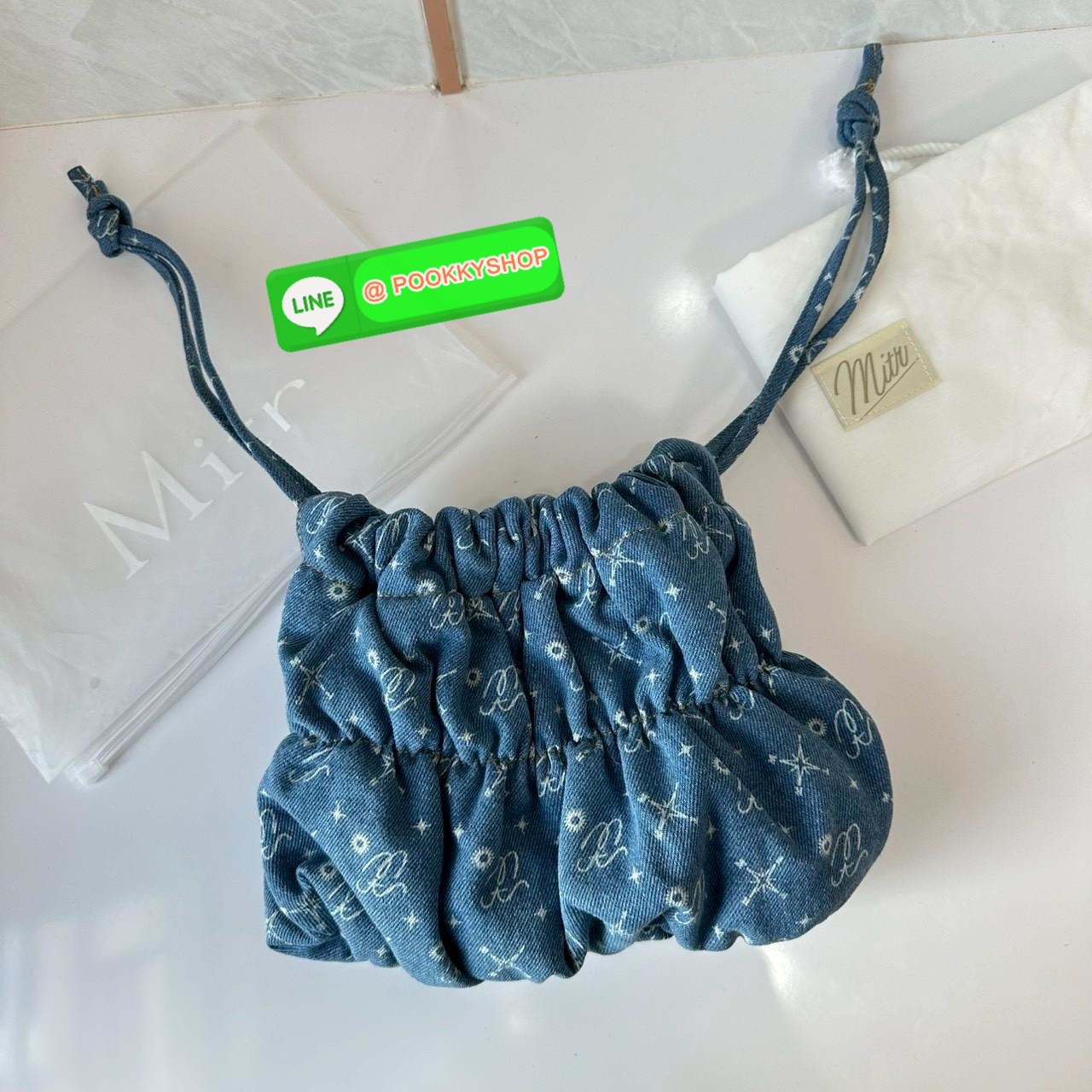 Mitr scrunchy bag 🔖กระเป๋ายีนส์สุดน่ารักเนื้อนุ่มพิมพ์ลาย Monogram ของ Mitr จุของได้เยอะรูปทรงแบบรูดได้ น้ำหนักเบาสุดๆ สะพายเป็น Shoulder Bag หรือถอดสายและถือเป็น Clutch Bag ก็ได้ ดีเทล Charm ห้อยโลหะสีเงิน โดดเด่นสุดๆ