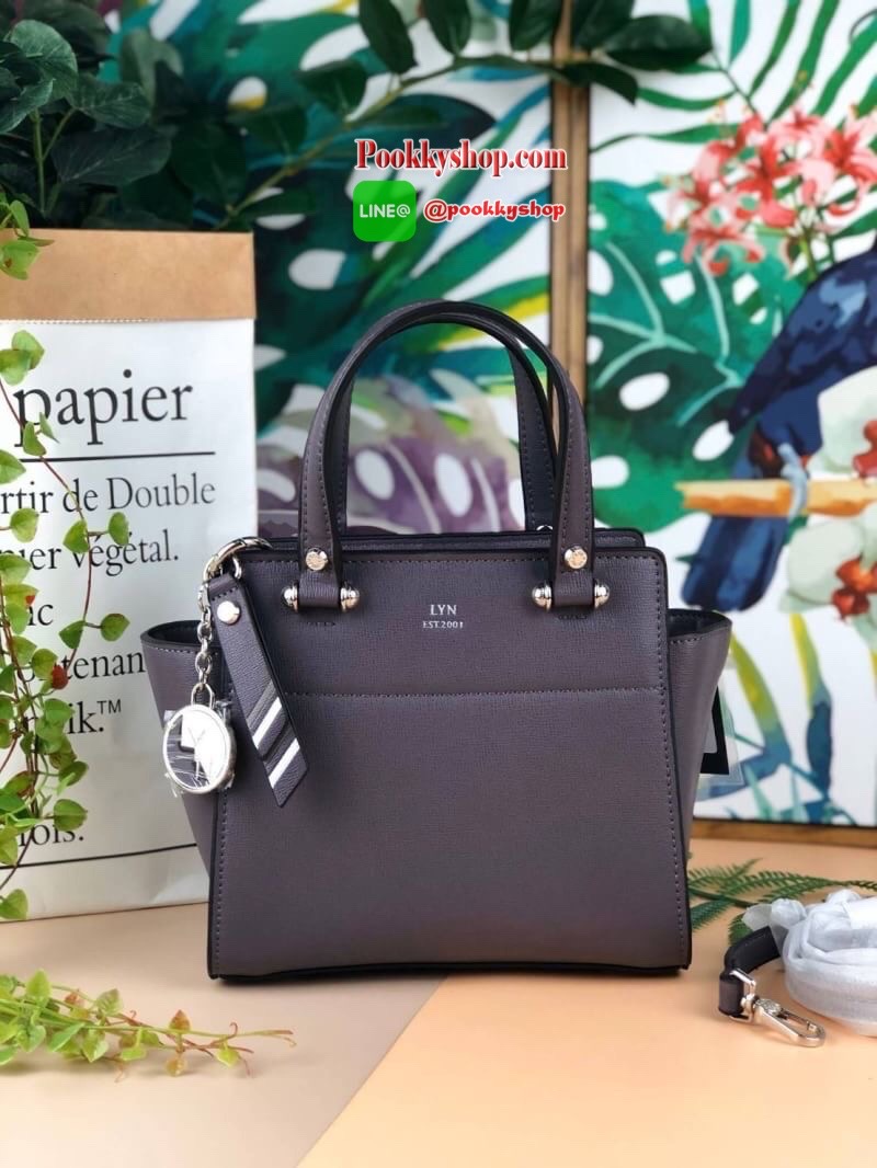 Lyn Handbag กระเป๋าถือ/สะพายวางอยู่ทรง ด้านหน้ามีปั๊มโลโก้แบรนด์ มาพร้อมพวงกุญแจหนังเข้าสีกระเป๋า มีหมุดรองฐานทั้ง 4 มุม หูหิ้วสามารถพับลงได้ เปิดปิดแบบซิป ด้านในมีช่องซิปเล็ก 1 ช่อง สามารถใส่ iPhone plus กระเป๋าเงินใบกลางได้สบายๆค่ะ มีสายสะพายยาวหนังปรับ