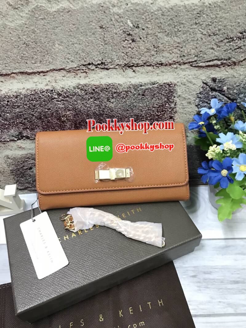ถุงผ้าแบรนด์+สายโซ่) CHARLES & KEITH BOW DETAIL LONG WALLET กระเป๋าสตางค์ยาวหนังลายคาร์เวียร์ ด้านหน้าประดับด้วยโบว์อะไหล่สีทอง เปิด-ปิดด้วยกระดุมแม่เหล็ก ภายในมีช่องซิปใส่เหรียญ บัตร และช่องธนบัตร มาพร้อมสายโซ่ร้อยหนัง สามารถถอดออกได้ ความยาวสาย40cm คล้อ