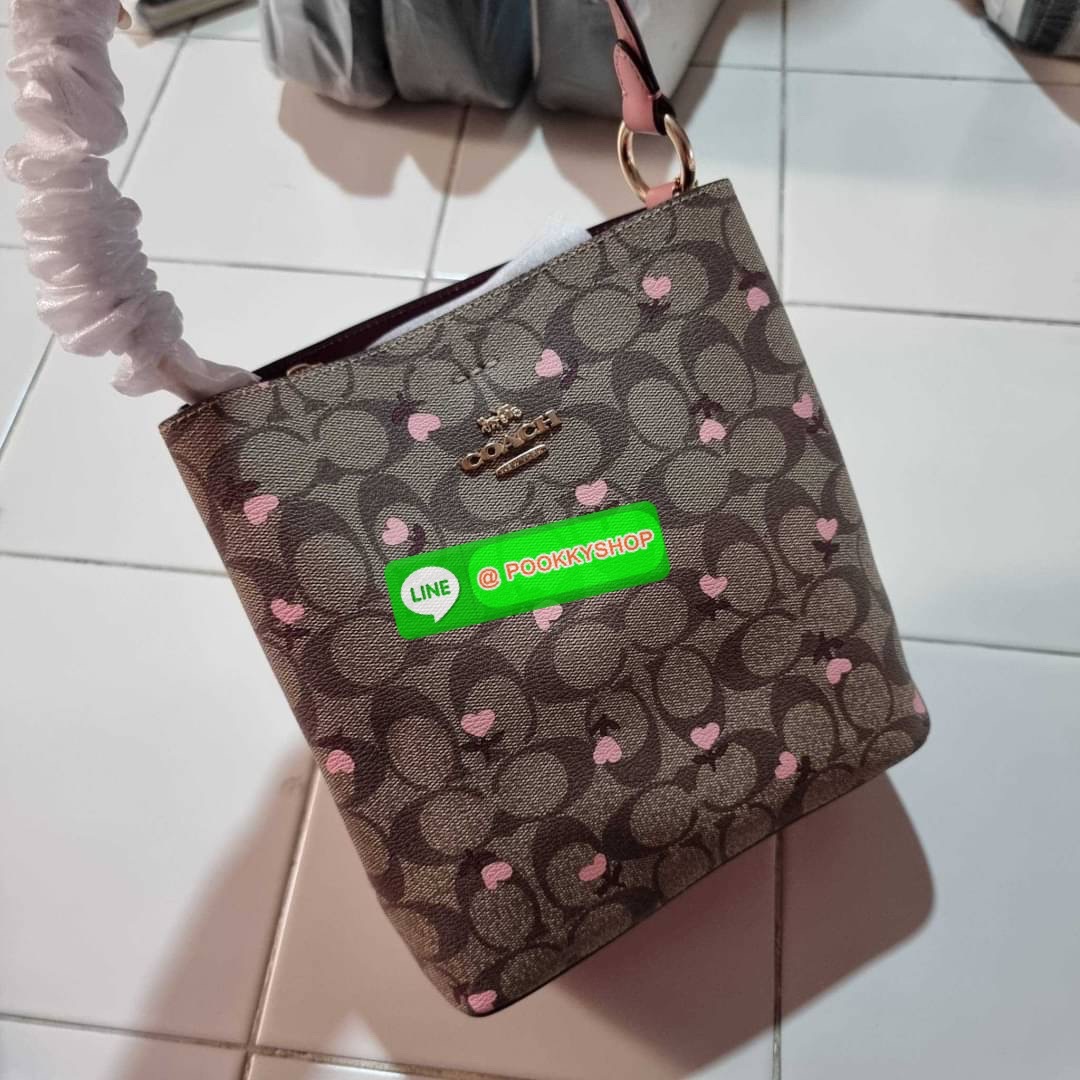 COACH C3238 SMALL TOWN BUCKET BAG IN SIGNATURE CANVAS WITH HEART FLORAL PRINT กระเป๋าบัคเก็ตน่ารักสดใส ลายพริ้นท์หัวใจเต็มใบ ดีไซน์ตัดกับสีกากีได้อย่างลงตัว วัสดุหนังแคนวาสเคลือบลาย ปากกระเป๋าเปิด-ปิดด้วยกระดุมแม่เหล็ก 2ฝั่ง มีหูจับในตัวและสายสะพายข้างมาใ