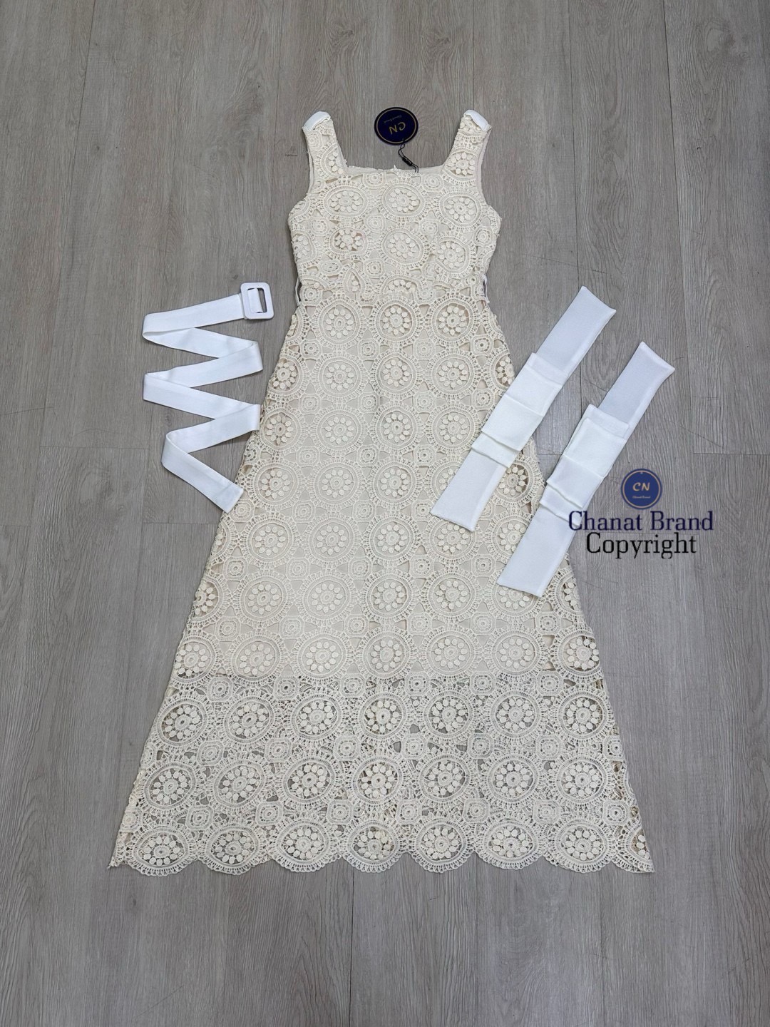 เดรสแฟชั่น เดรสยาวเนื้อผ้าลูกไม้ฉลุวงกลม ดีไซน์แขนกุดตรงบ่าแต่งโบว์ใหญ่สีครีมทั้งสองข้าง