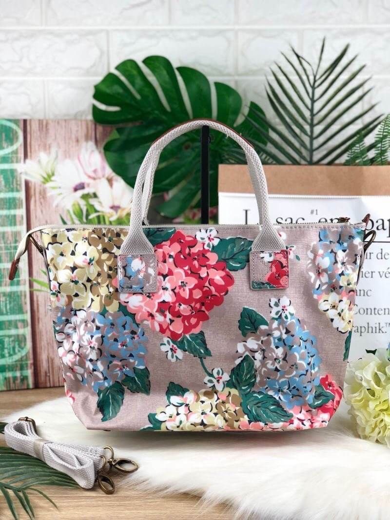 CATH KIDSTON HANDBAG กระเป๋าถือ/สะพายทรงสวย ด้านหน้ามีช่องซิปใส่ของจุกจิกได้ มีหมุดรองฐาน 4 มุม หูหิ้วมีหนังรองมือ เปิดปิดด้วยซิปบน ด้านในกว้างจุของได้เยอะ มีช่องซิปเล็ก 1 ช่อง มาพร้อมสายสะพายยาวถอดและปรับสายได้ รุ่นนี้น้ำหนักเบา ใช้งานง่ายได้หลายโอกาส มี