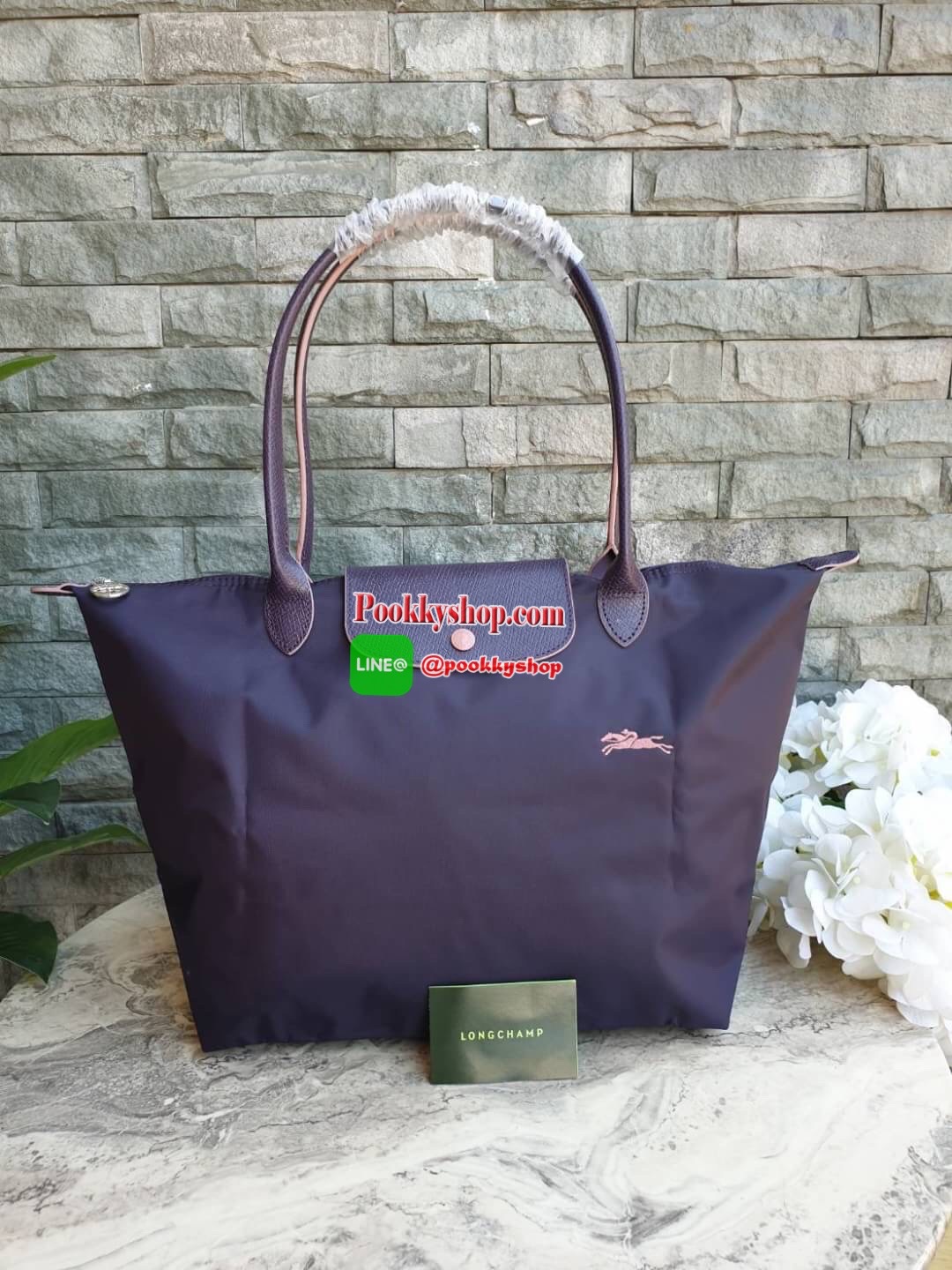 Longchamp Le Pliage Club Tote Bag Size L หูยาว วัสดุเนื้อผ้า Nylon Canvas เคลือบกันนำ้ ตัดด้วยหนังแท้ที่มีน้ำหนักเบา ดีไซน์เรียบง่ายแต่เต็มไปด้วยความคลาสสิก จนเป็นที่ชื่นชอบไปทั่วโลก Longchamp ปรับโฉม LE PLIAGE ด้วยการปักลายรูปม้า-ตราสัญลักษณ์ของแบรนด์บนผ