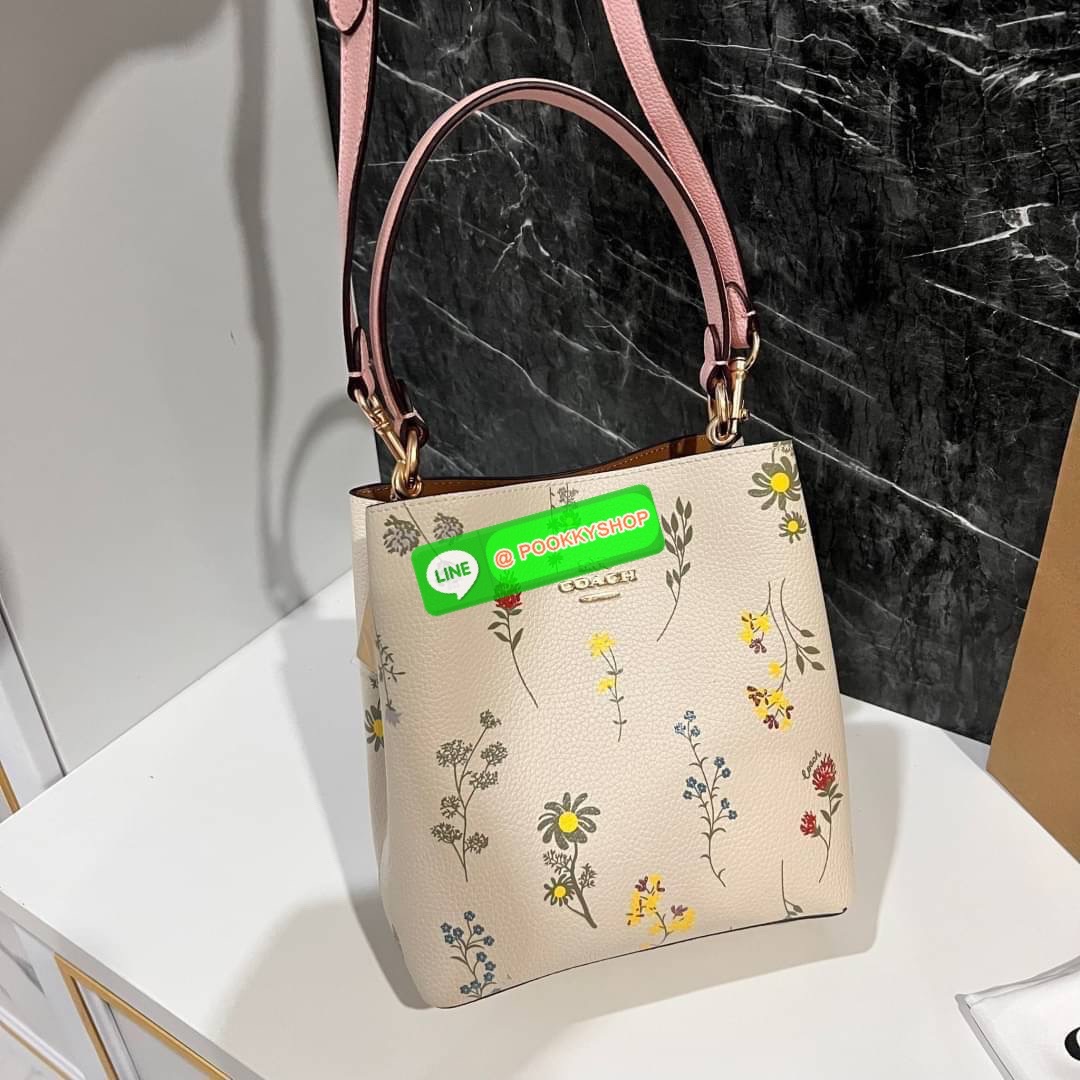 COACH C3598 SMALL TOWN BUCKET WITH SPACED WILDFLOWER PRINT มีความน่ารักละมุนมาก กระเป๋าทรงบัคเก็ต ดีไซน์ดอกไม้คละรอบใบ วัสดุหนังแท้ปากกระเป๋าเปิด-ปิดด้วยกระดุมแม่เหล็ก 2 มีหูจับในตัวและสายสะพายข้าง ภายในโล่งกว้าง มีช่องซิปแยกสัดส่วนตรงกลาง สายสะพายปรับระด