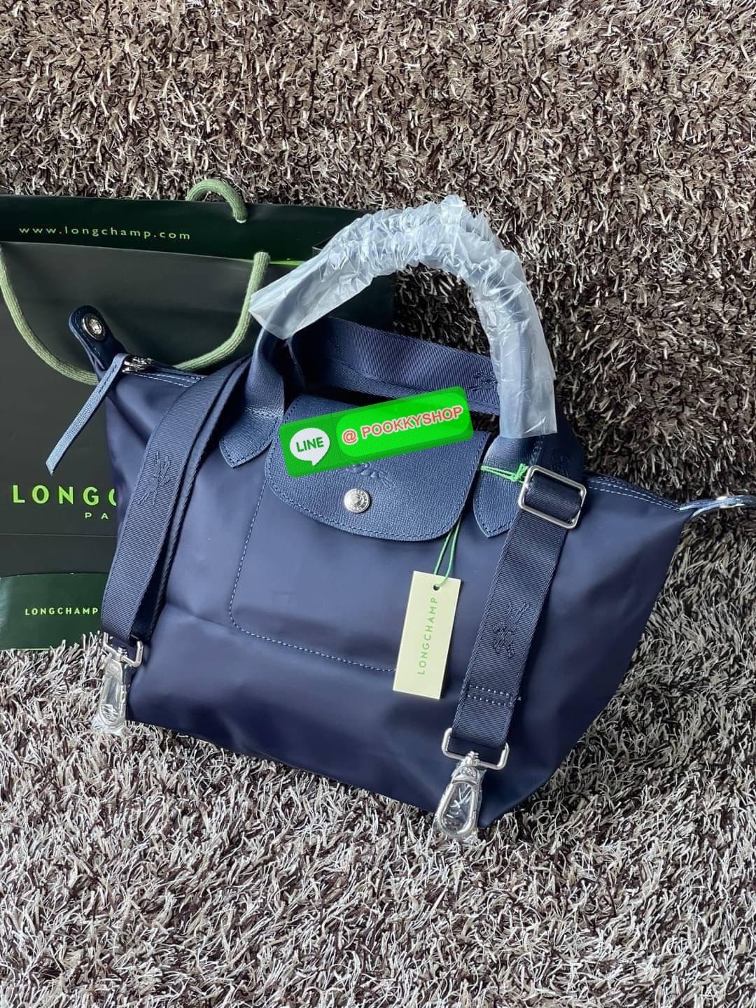💕Longchamp LE PLIAGE NÉO TOP HANDLE BAG (small size) อีกหนึ่งรุ่นยอดนิยม ที่สาวๆ ต้องมีไว้เก็บไว้สักใบ กระเป๋าโท้ทใบนี้ มาพร้อมกับสีที่มีสไตล์เรียบง่าย มีสายสะพายยาวปรับสั้นยาวได้ช่วยให้คุณสามารถสะพายไหล่ได้อย่างสบาย ในตัวสายปักโลโก้อันเป็นสัญลักษ