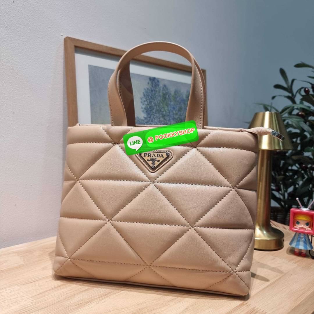 PRADA LEATHER PADDED BAG ใหม่ล่าสุด กับคอลเลคชั่นที่ทำออกมาตอบโจทย์ได้ทุกไลฟ์สไตล์ และเป็นยูนิเซ็กส์ กับกระเป๋าทรงโท้ท ขนาดกำลังดี วัสดุหนังแท้ ตัดเย็บเดินเส้นลายตาราง ปากกระเป๋ามีซิปเปิดปิด ภายในเป็นช่องโล่ง มีช่องแยกให้ มาพร้อมสะพายข้างและใบลูก ให้ได้สน