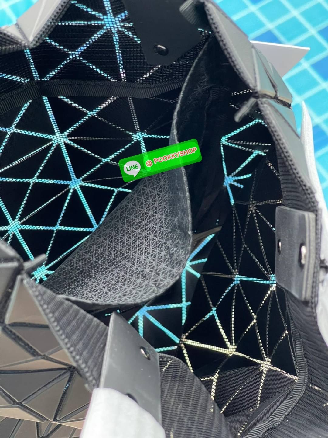 Baobao Issey Miyake Prism Kangaroo tote bag กระเป๋าถือทรงโท้ทที่ประดิษฐ์ขึ้นอย่างเชี่ยวชาญในญี่ปุ่น มาพร้อมแผงเรขาคณิตสำหรับการออกแบบที่ได้รับแรงบันดาลใจจากกระดาษพับ ซิลลูเอทอันเป็นเอกลักษณ์นี้ปิดท้ายด้วยสายรัดแบบอสมมาตร มีการพัฒนาโครงสร้างทรงสามเหลี่ยมเพ