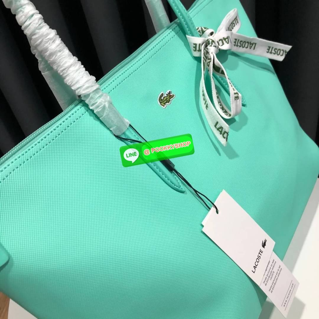 ลาคอส Classic Tote Bag กระเป๋าสะพายทรงช้อปปิ้งหลากสีรุ่นยอดนิยมด้านหน้าประดับโลโก้จระเข้สัญลักษณ์แบรนด์ ภายในกว้างจุได้เยอะ เปิดปิดด้วยซิปสะดวกใช้ มี1 ช่องซิปเล็ก หัวซิปปั้มเเบรนด์ วัสดุกันน้ำ ขนาดกำลังดี ใส่หนังสือ เอกสารA4 ของใช้ได้เยอะ สวยทุกสีค่ะ